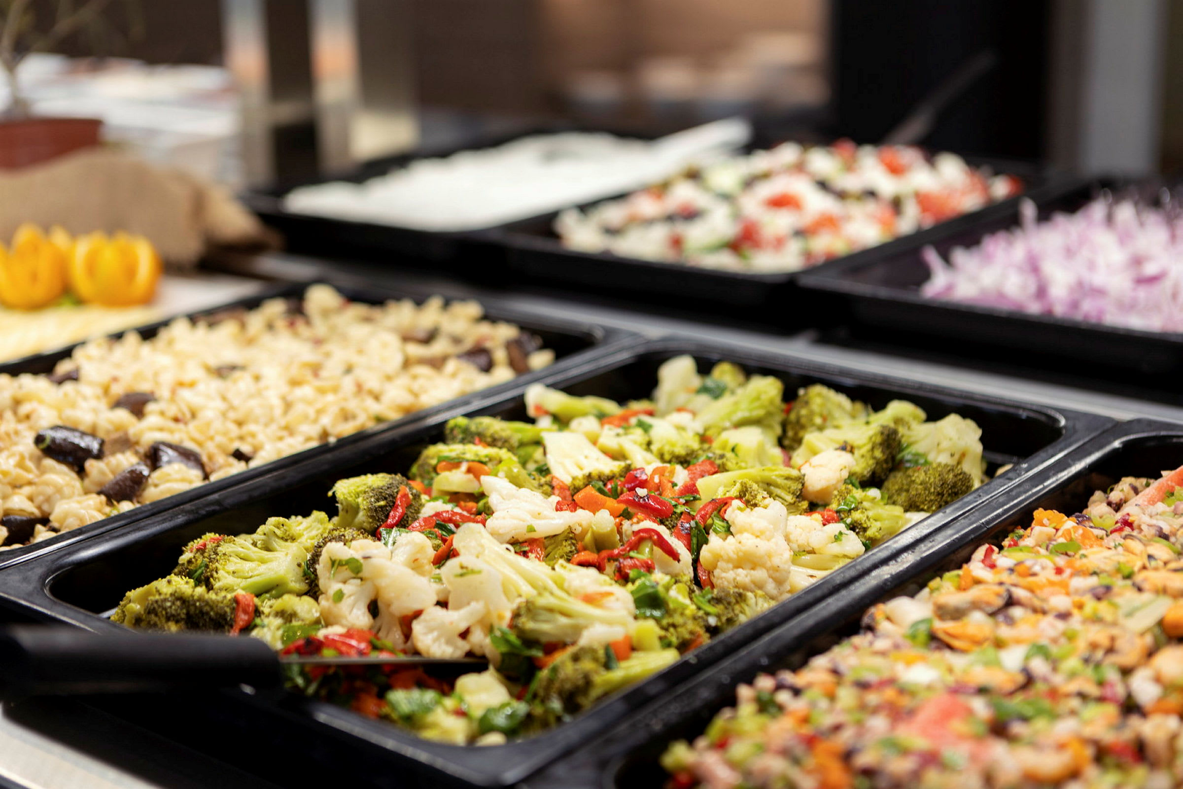 Buffet, jossa erilaisia ruokalajeja, kuten pastaa ja vihanneksia. (Tekoälyn luoma teksti)