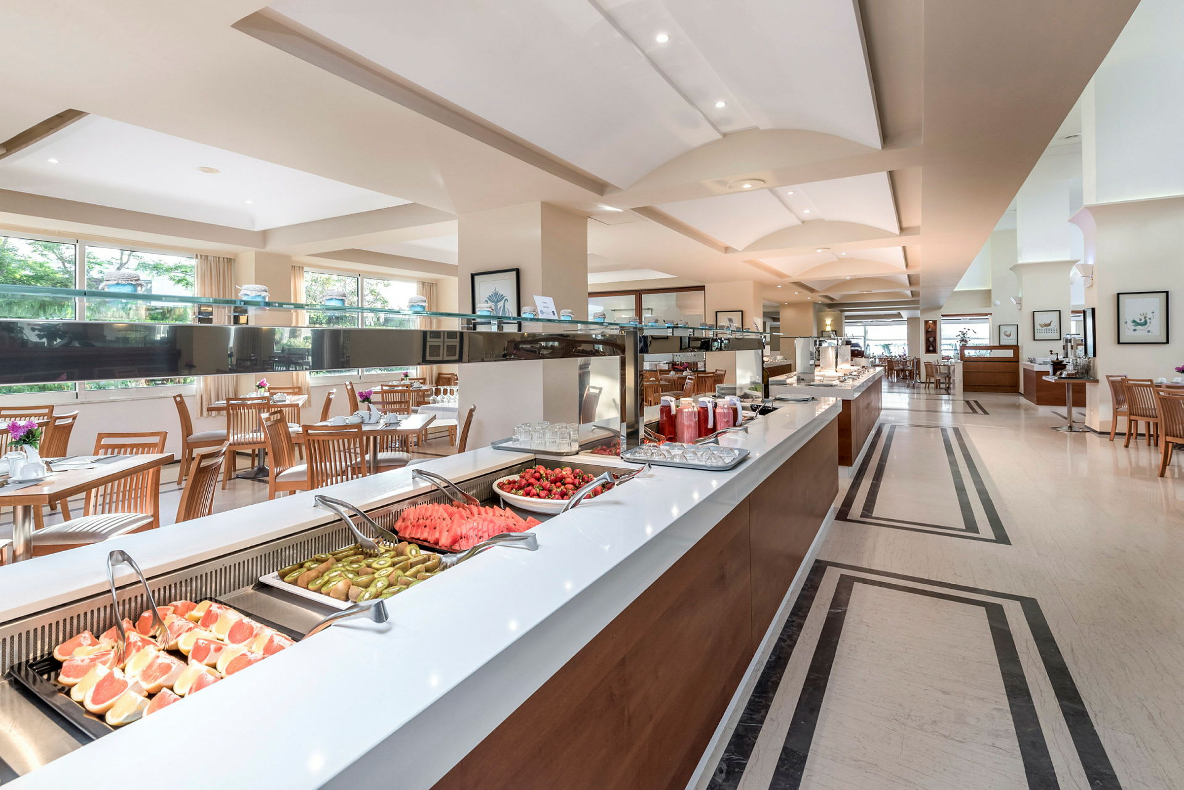 Buffet-alue hedelmien ja mehujen kanssa valoisassa ruokailutilassa. (Tekoälyn luoma teksti)