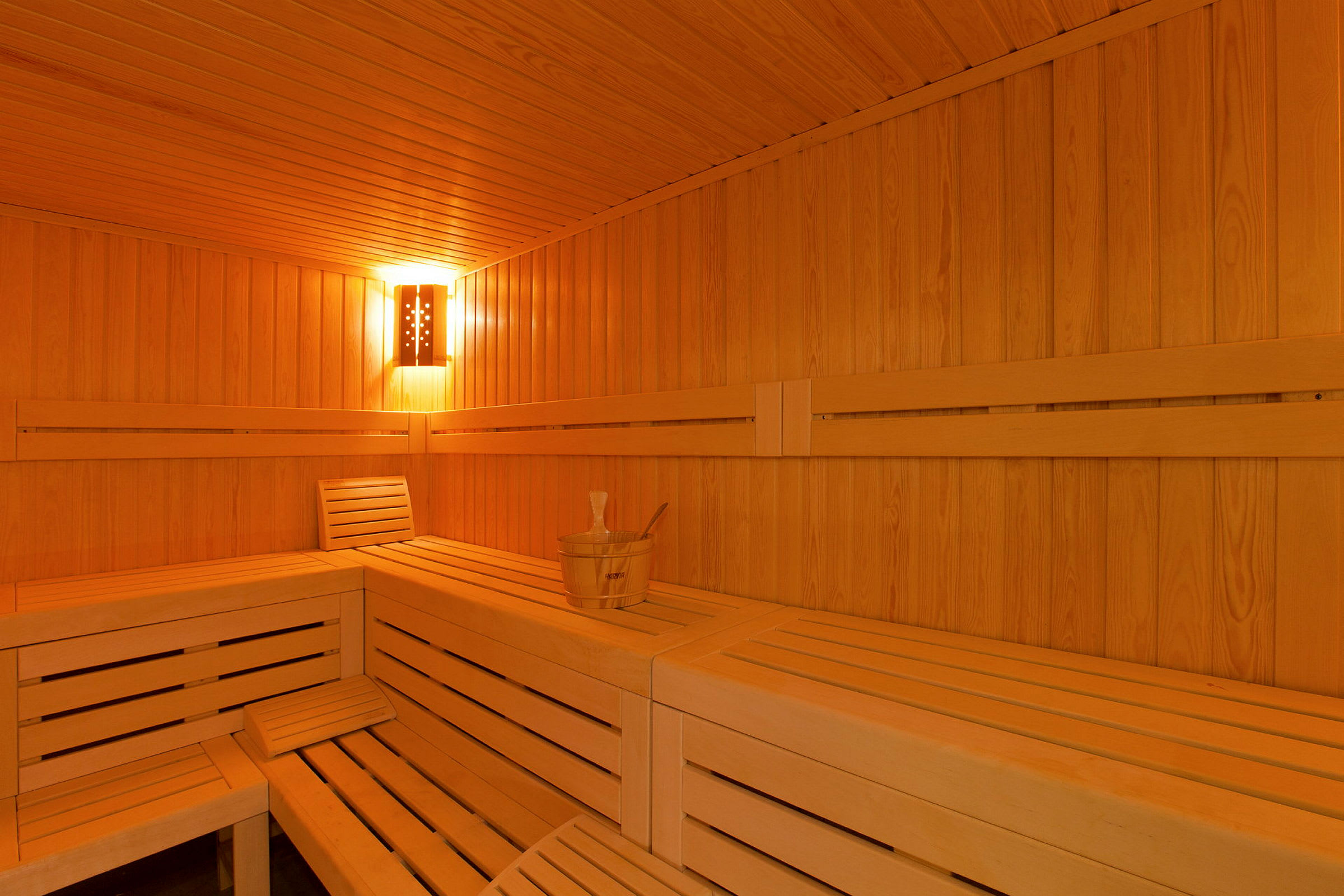 Puupintainen sauna, jossa penkkejä ja vesikippo. (Tekoälyn luoma teksti)