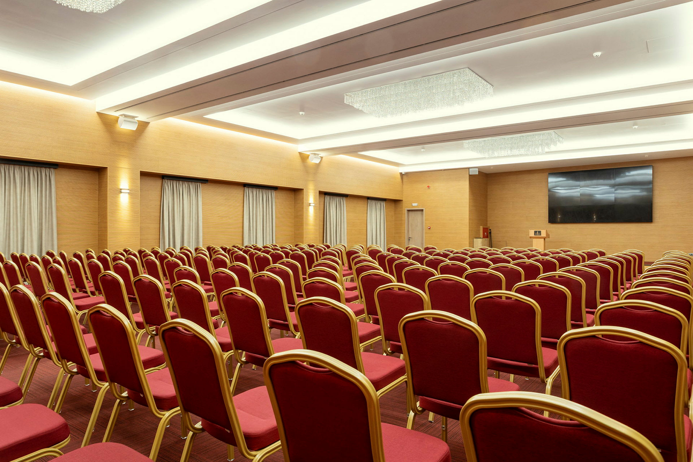 Konferenssihuone, jossa punaiset tuolit ovat rivissä. (Tekoälyn luoma teksti)