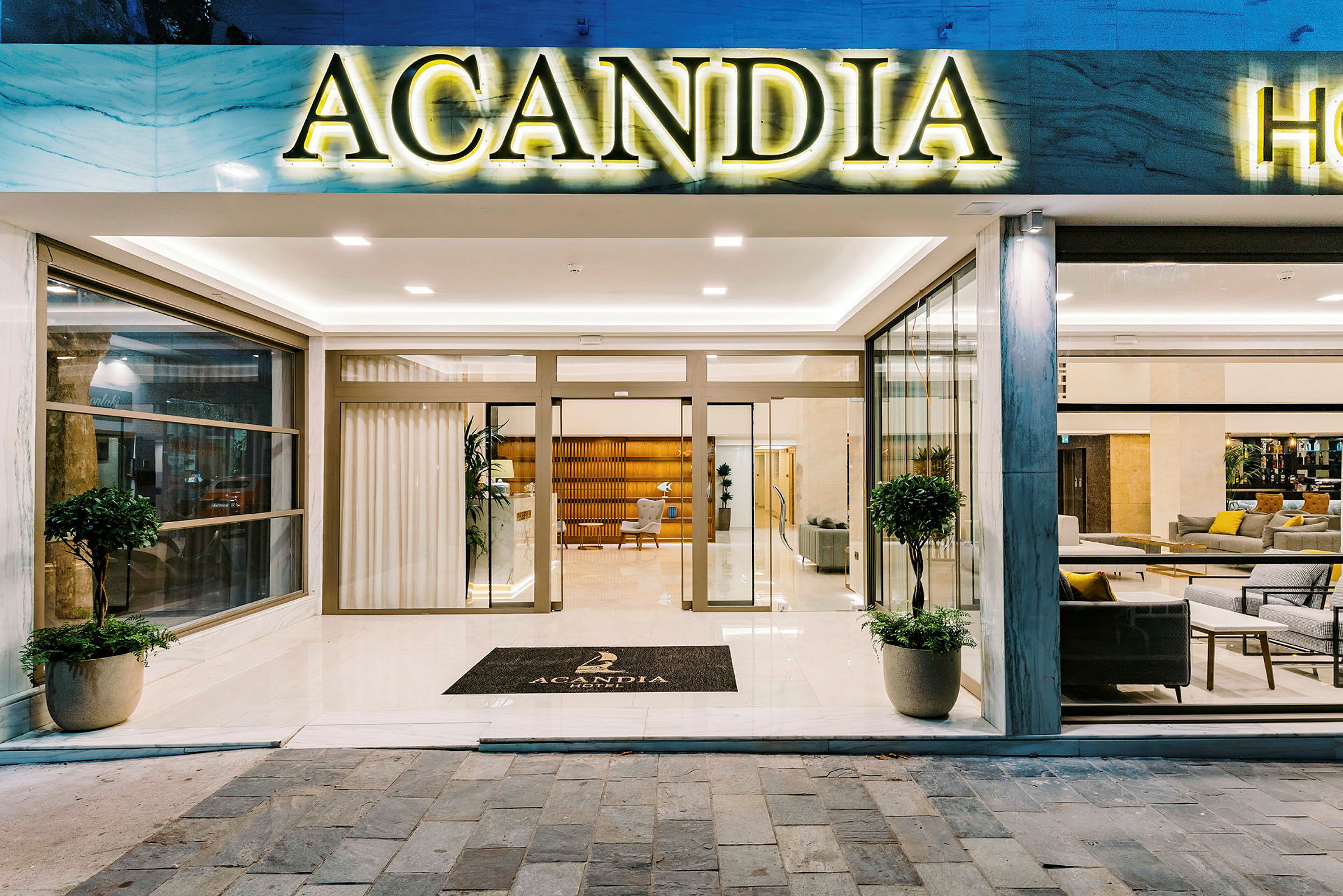 Acandia-hotellin sisäänkäynti, jossa lasiovet ja hotellin nimen sisältävä kyltti. (Tekoälyn luoma teksti)
