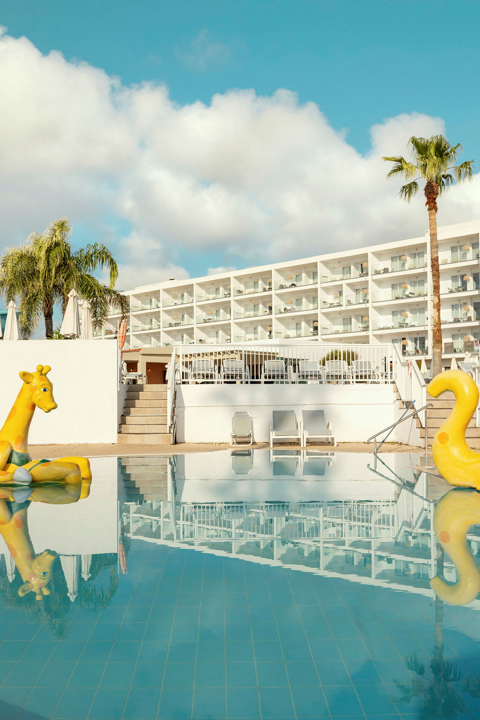 Kuva hotellista, jossa on uima-allas ja kaksi keltaista puhallettavaa lelua. (Tekoälyn luoma teksti)