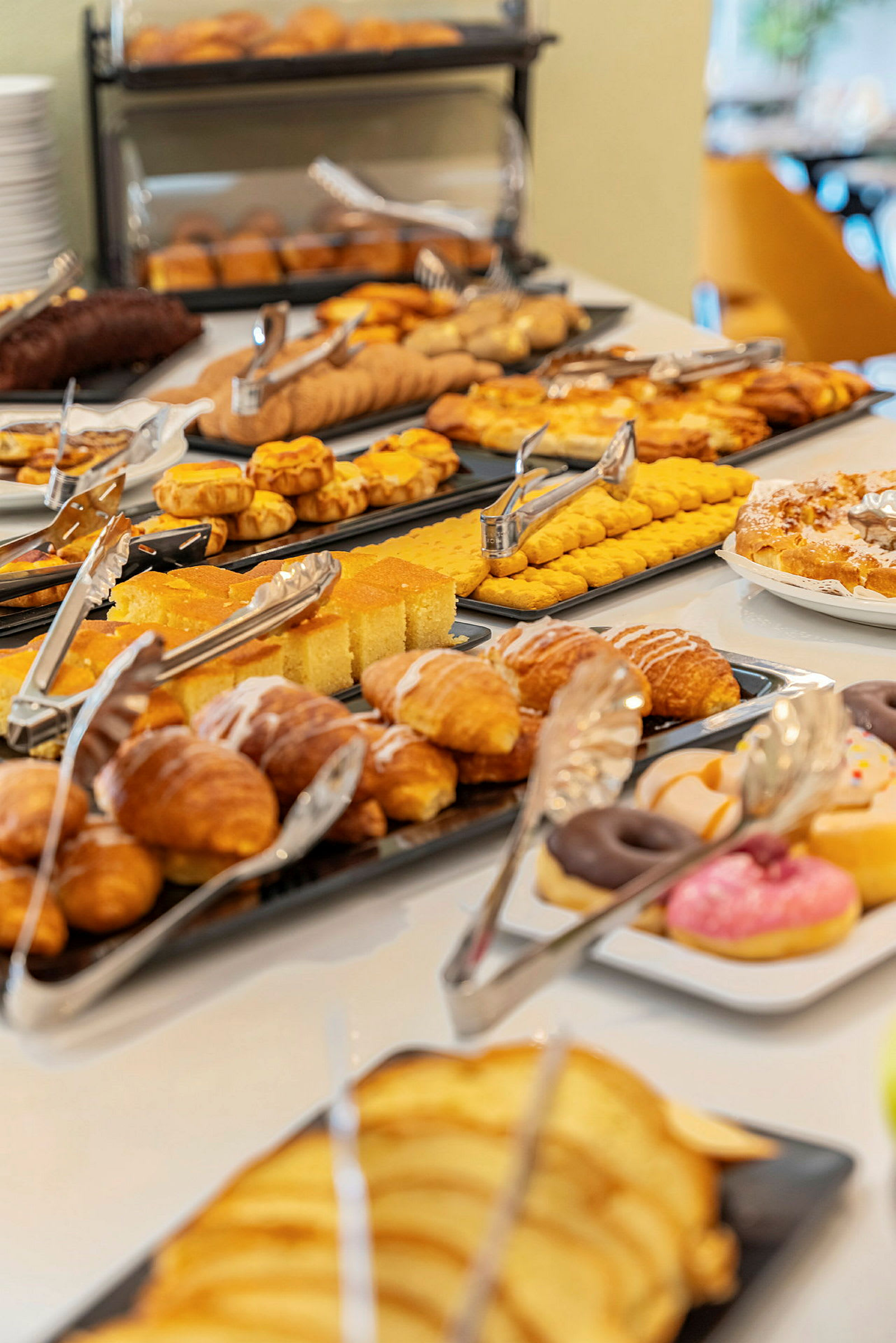 Buffet, jossa erilaisia leivonnaisia ja leipiä. (Tekoälyn luoma teksti)
