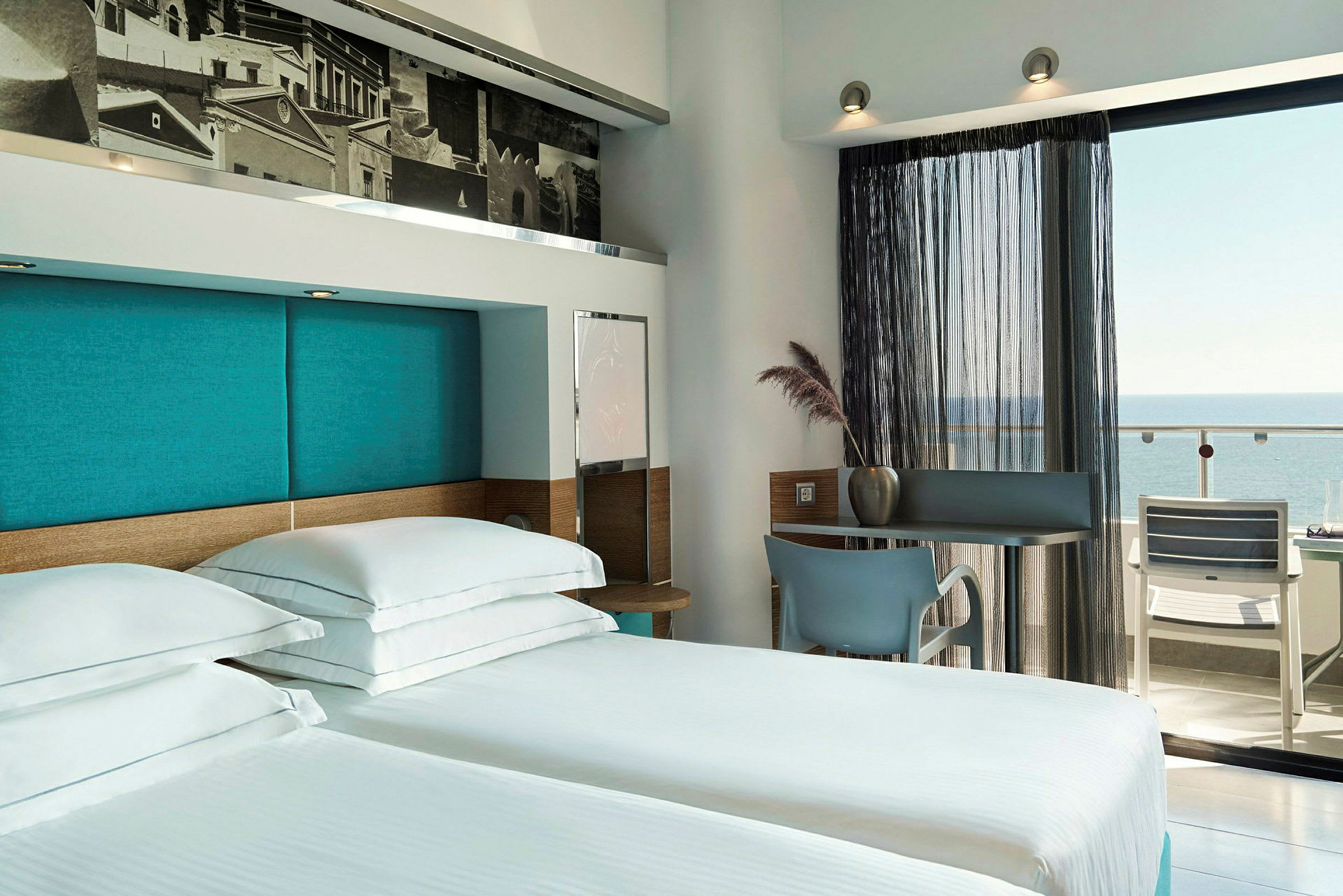 Hotellihuone, jossa kaksi vuodetta ja näkymä parvekkeelle merinäköalalla. (Tekoälyn luoma teksti)