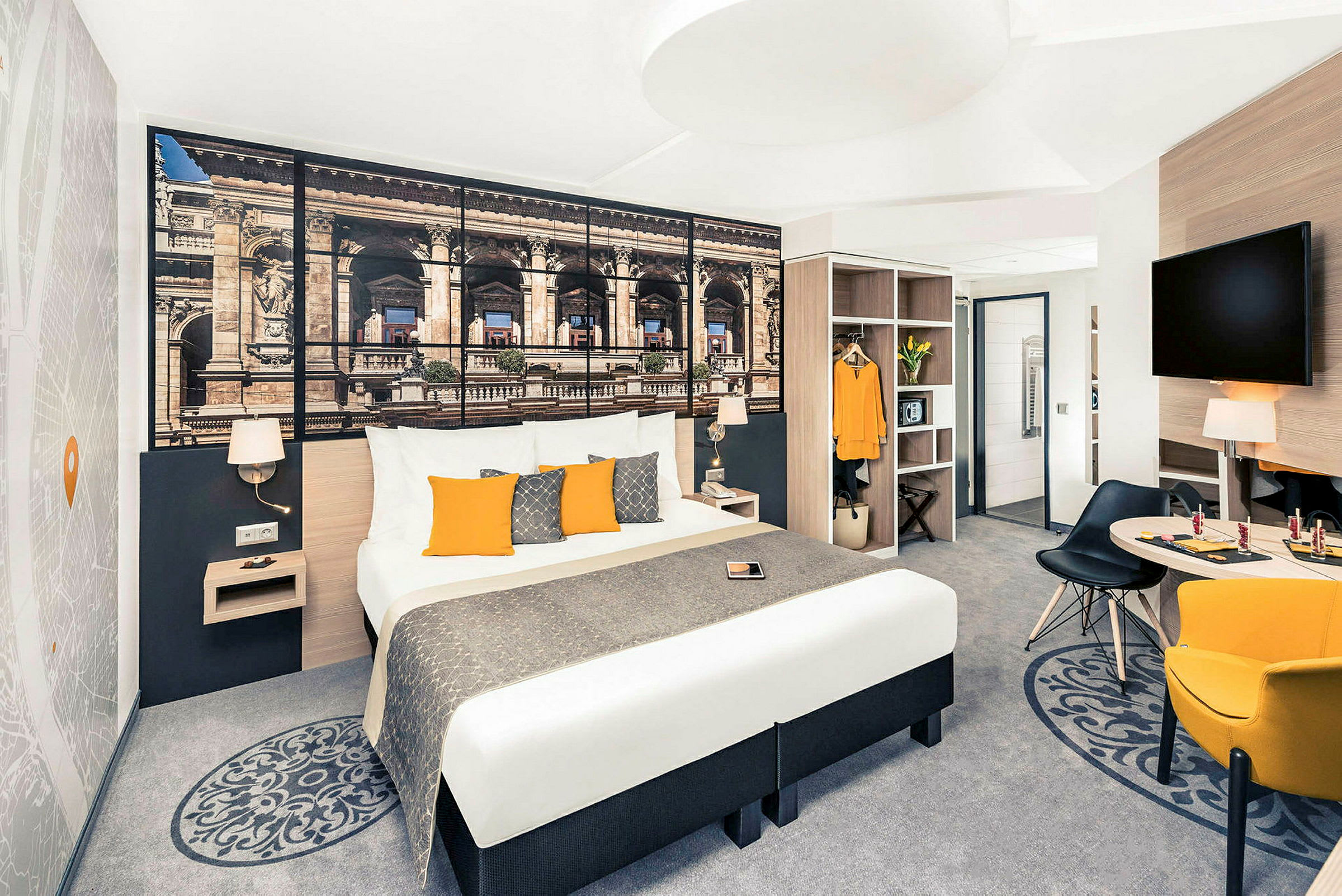 Hotellihuone, jossa on parivuode, seinäkoriste, istuinnurkkaus ja vaatekaappi. (Tekoälyn luoma teksti)
