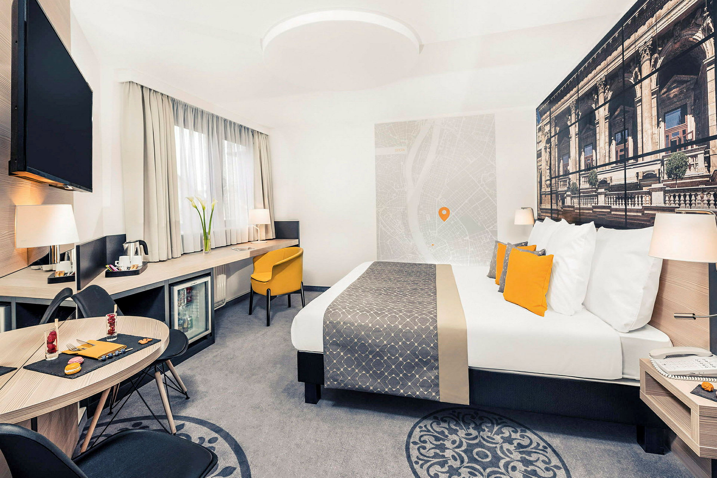 Moderni hotellihuone, jossa on parivuode, kirjoituspöytä ja oleskelutila. (Tekoälyn luoma teksti)