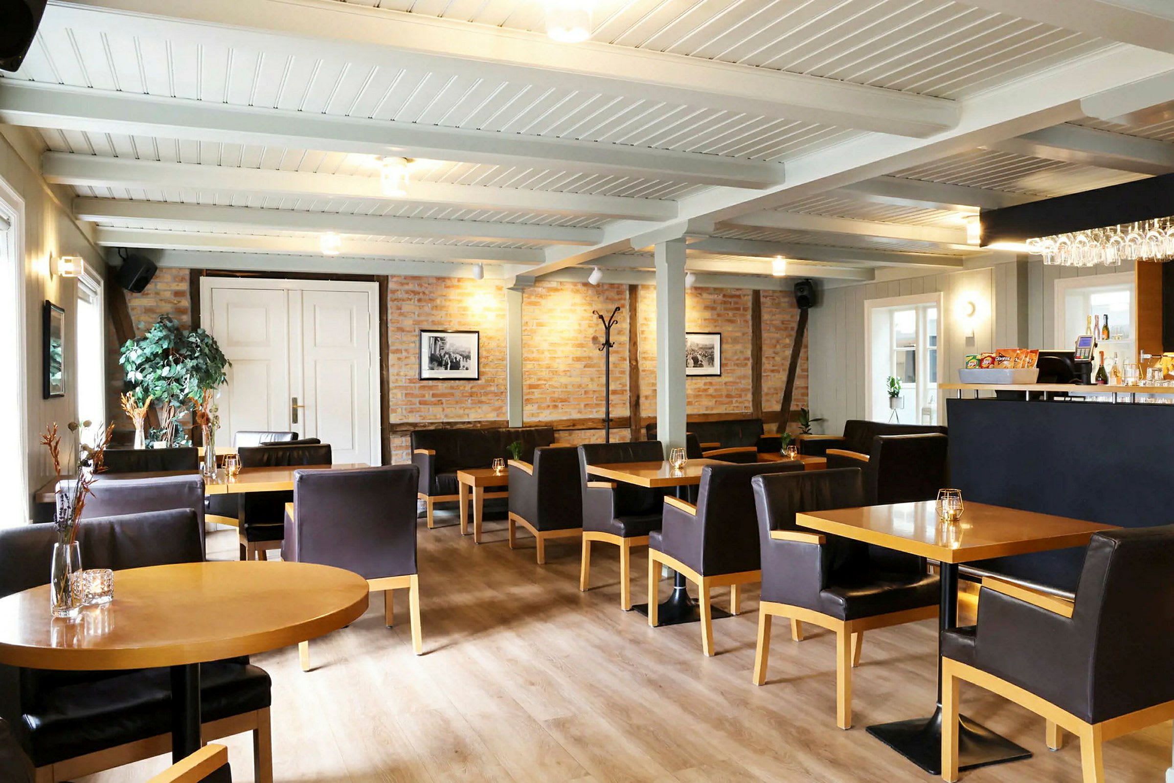 Sisätilan ravintola, jossa on pöytiä, tuoleja ja baari. (Tekoälyn luoma teksti)