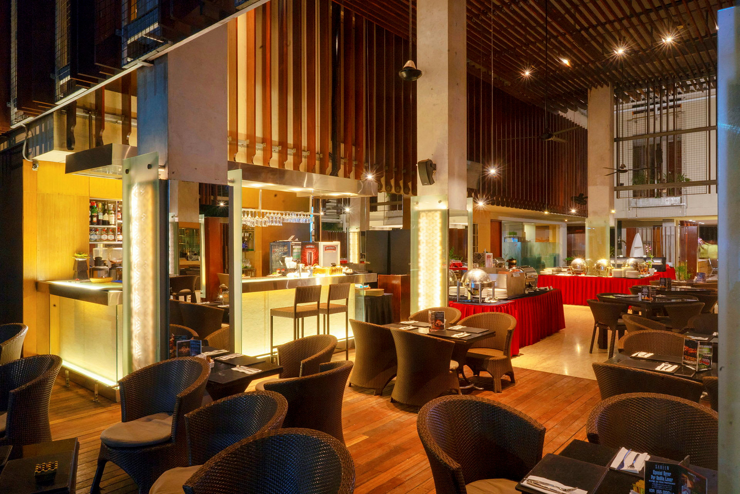 Ravintola, jossa on buffet ja istumapaikkoja, sisustettu puuelementeillä ja lämpimällä valaistuksella. (Tekoälyn luoma teksti)