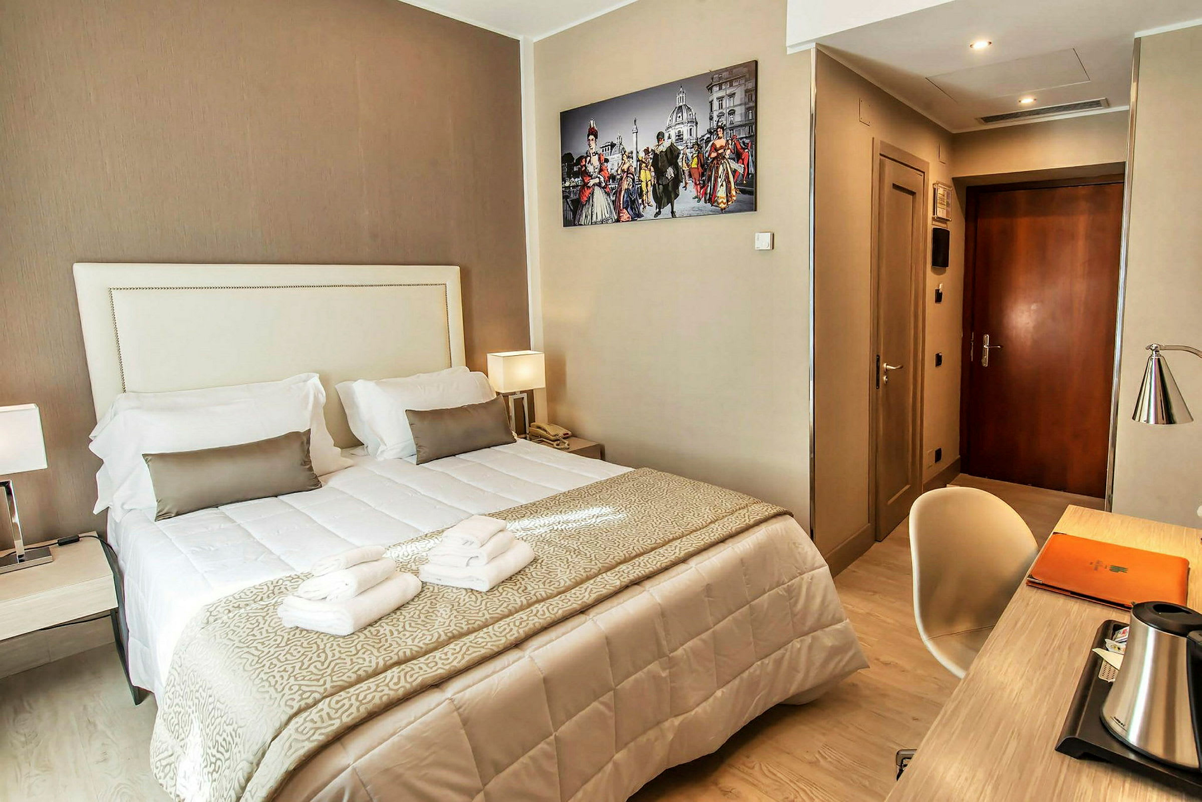 Hotellihuone, jossa on parisänky, työpöytä ja seinäkuva. (Tekoälyn luoma teksti)