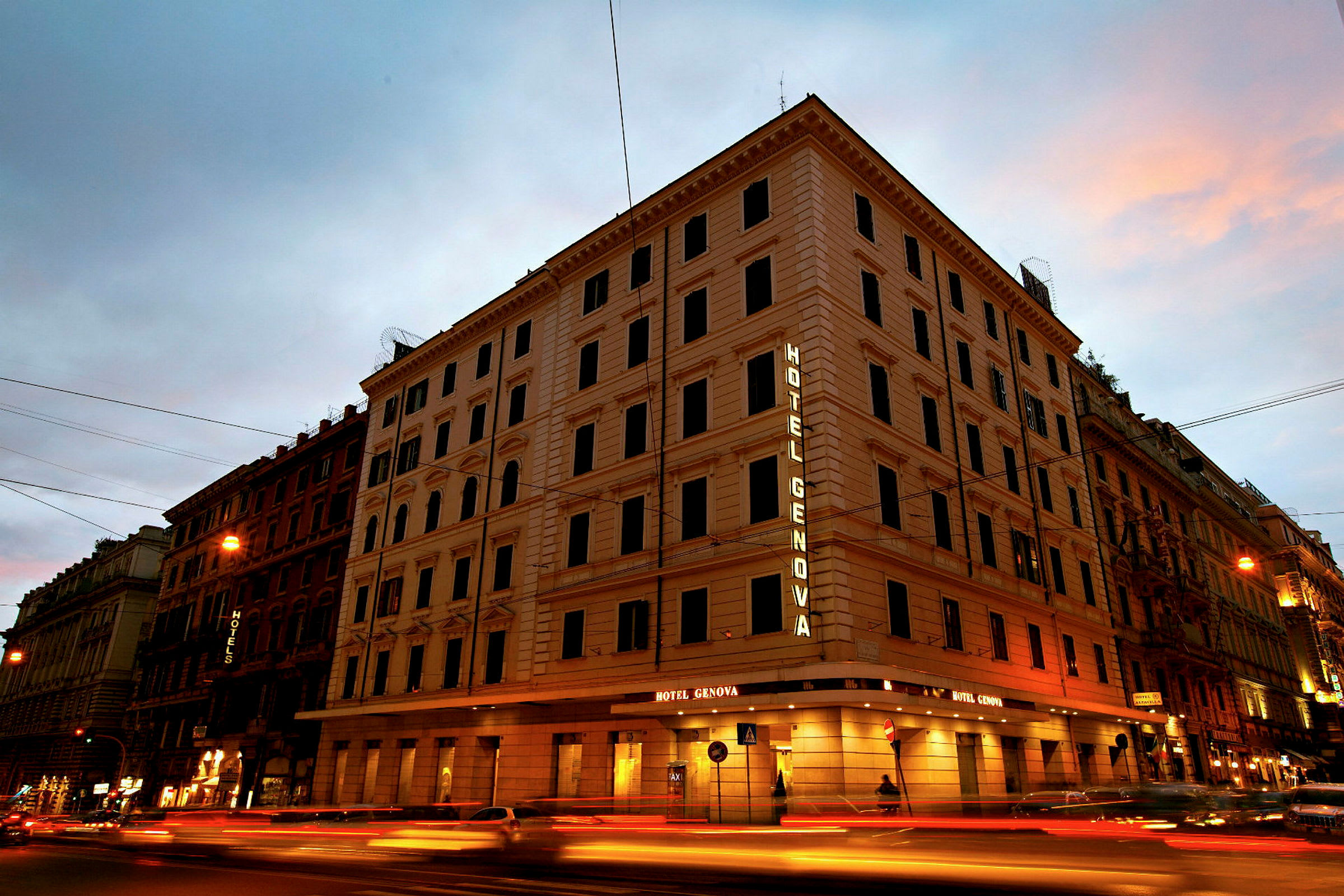 Useamman kerroksen rakennus, jonka julkisivussa lukee valaistuna Hotel Genova. (Tekoälyn luoma teksti)