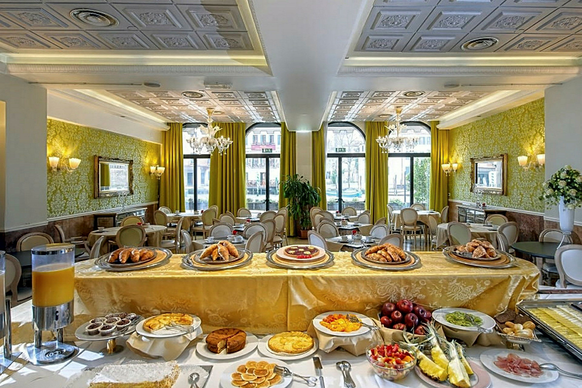 Tyylikäs ruokailutila hotelliravintolassa, jossa on buffet leipää, kakkua ja tuoreita hedelmiä. (Tekoälyn luoma teksti)