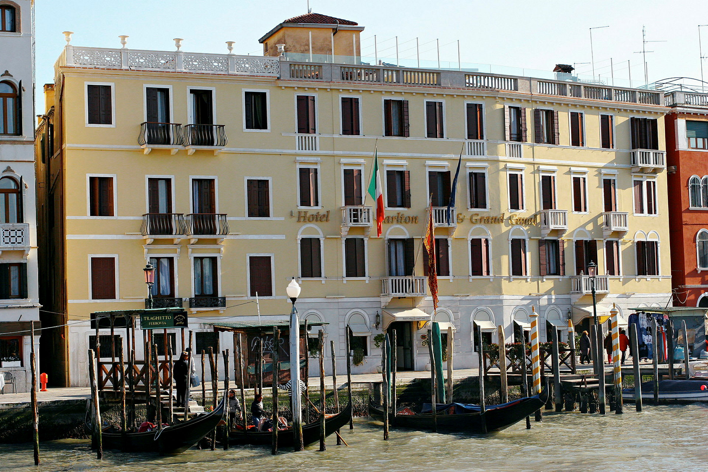 Keltainen hotelli Venetian Grand Canalilla gondoleineen edessä. (Tekoälyn luoma teksti)