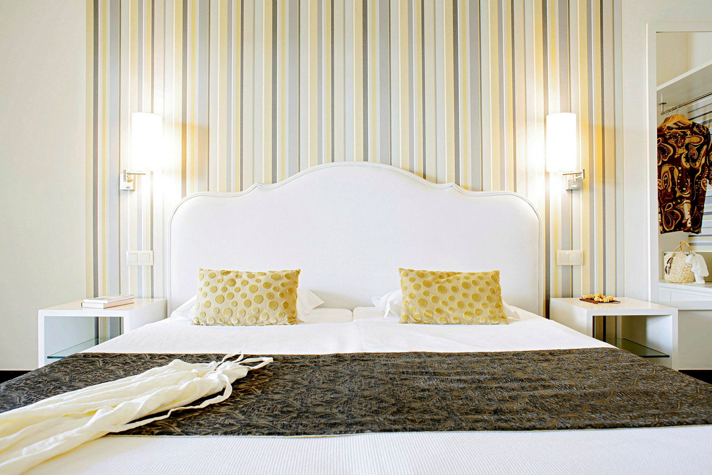 Parivuode, jossa on valkoisia ja keltaisia yksityiskohtia, huoneessa raidoitetut tapetit. (Tekoälyn luoma teksti)