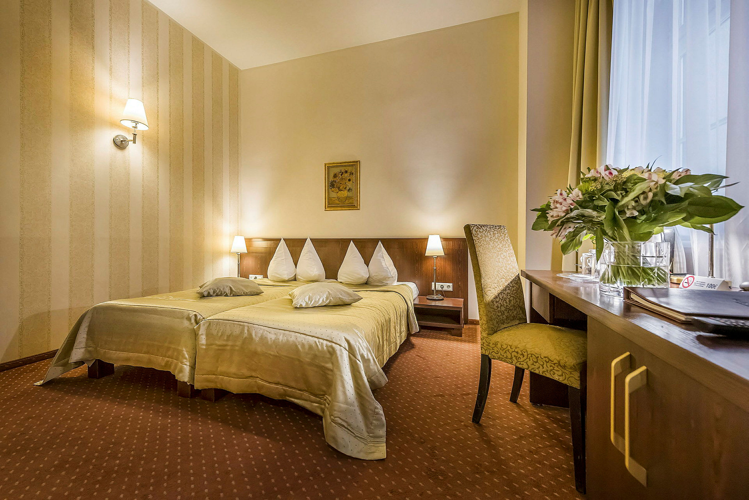 Hotellihuone, jossa on parivuode, yöpöydät ja työpöytä tuolilla. (Tekoälyn luoma teksti)