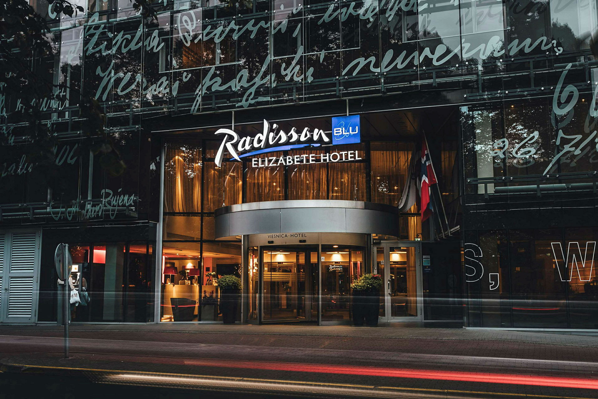 Hotellin sisäänkäynti, jossa on kyltti "Radisson Blu Elizabete Hotel". (Tekoälyn luoma teksti)