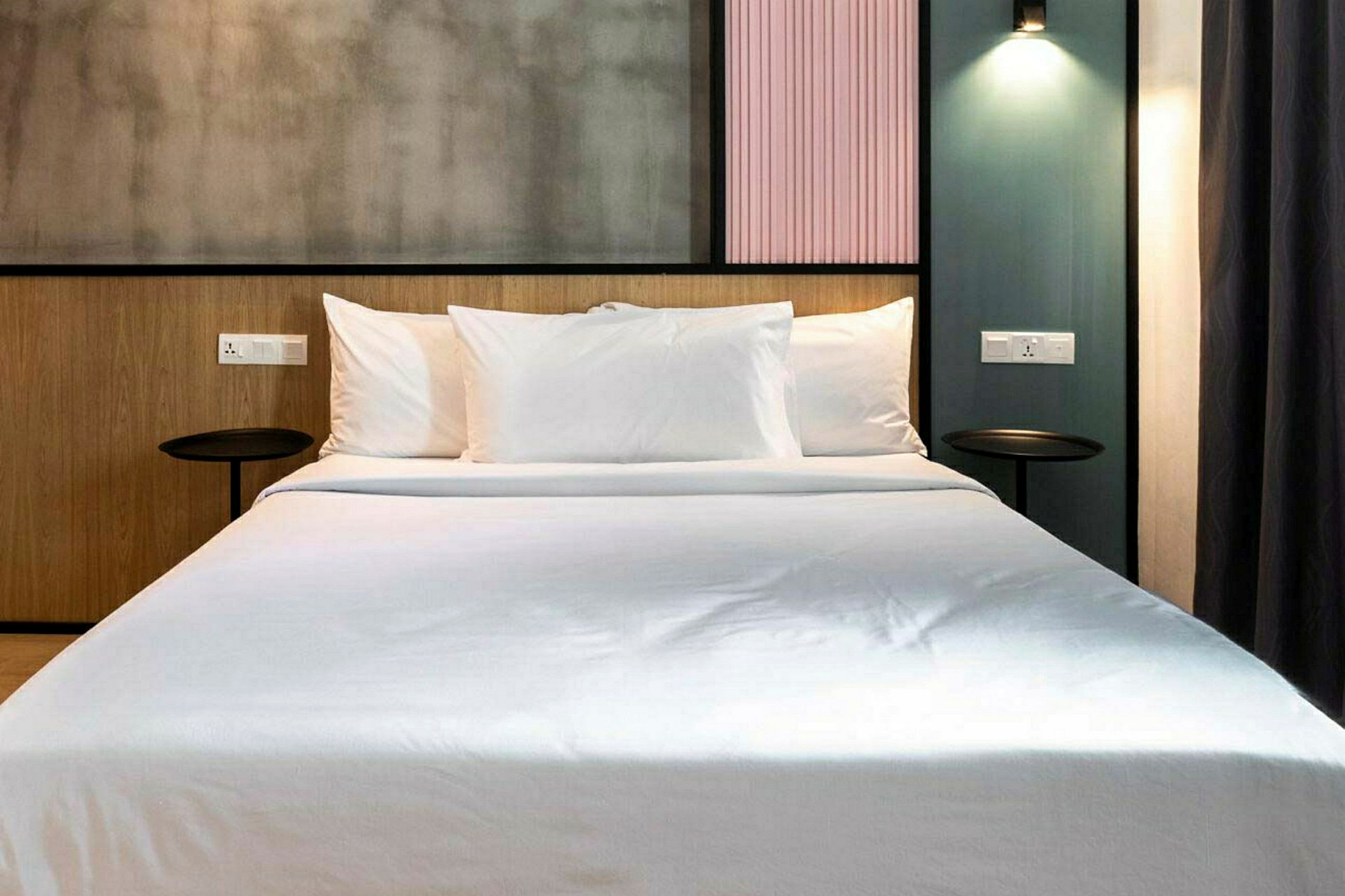 Moderni hotellihuone pedatulla vuoteella ja tyylikäs tausta. (Tekoälyn luoma teksti)