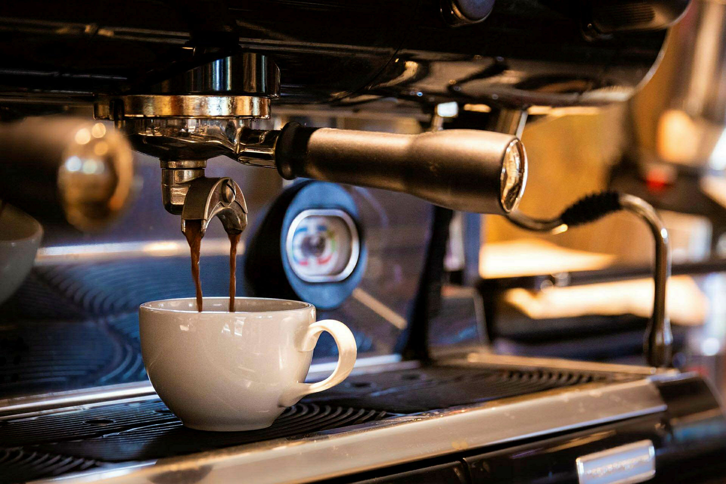 Espressokone keittää kahvia, joka valuu valkoiseen kuppiin. (Tekoälyn luoma teksti)