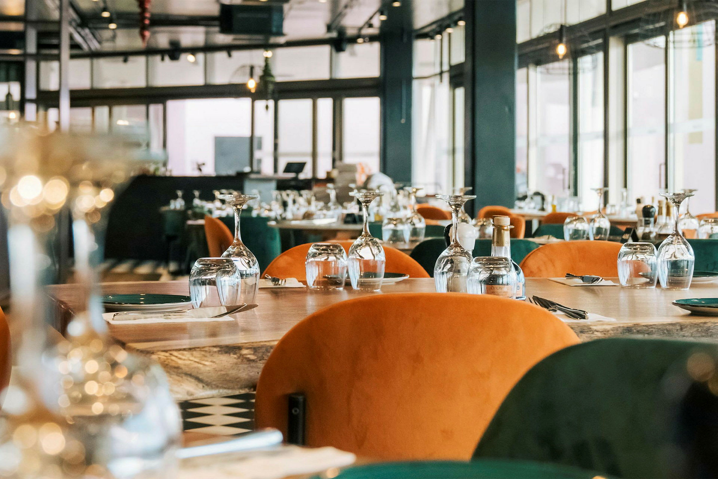 Ravintola, jossa pöydät on katettu laseilla ja aterimilla asiakkaita varten. (Tekoälyn luoma teksti)