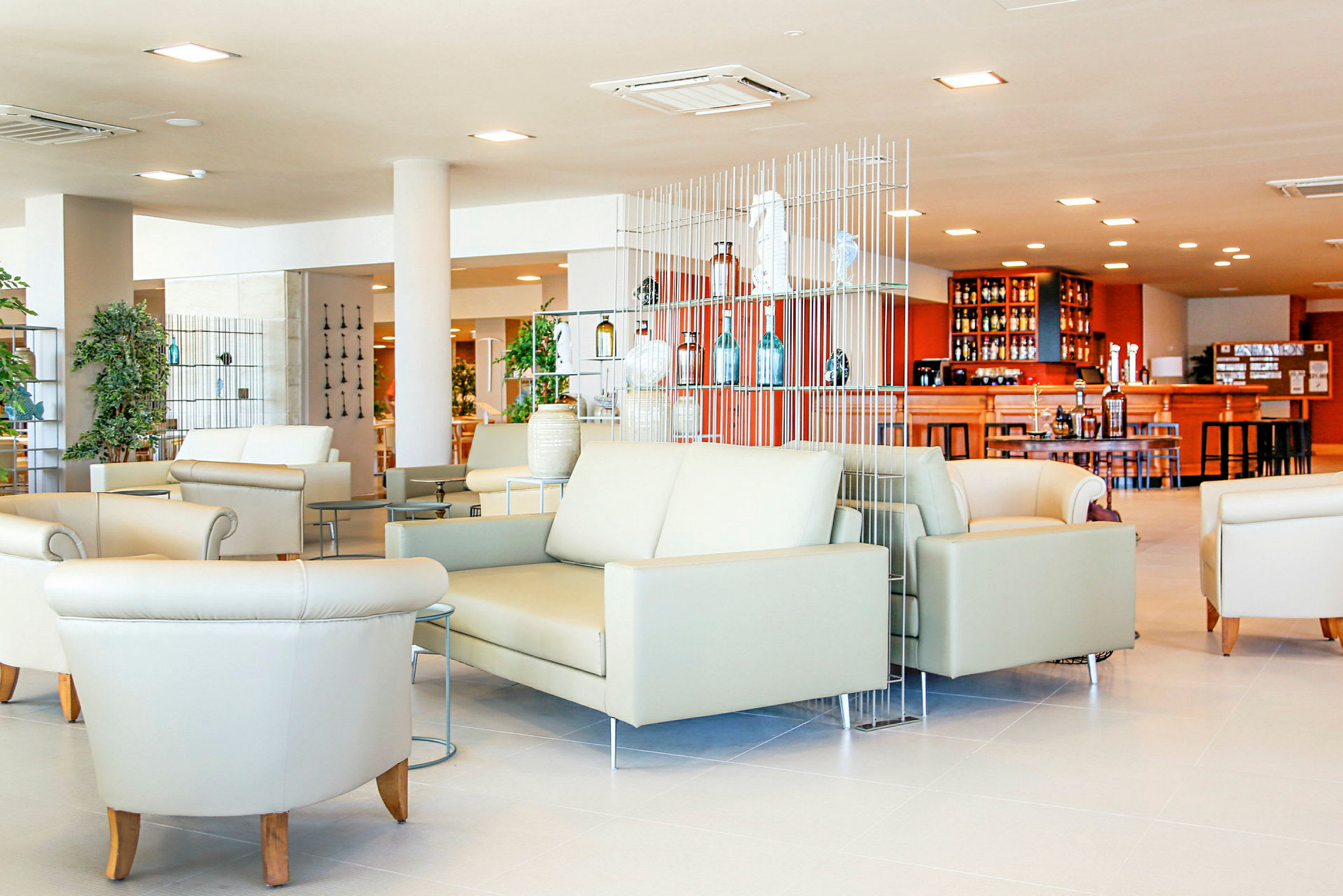 Valoisa ja moderni lounge, jossa sohvia ja nojatuoleja sekä baari taustalla. (Tekoälyn luoma teksti)