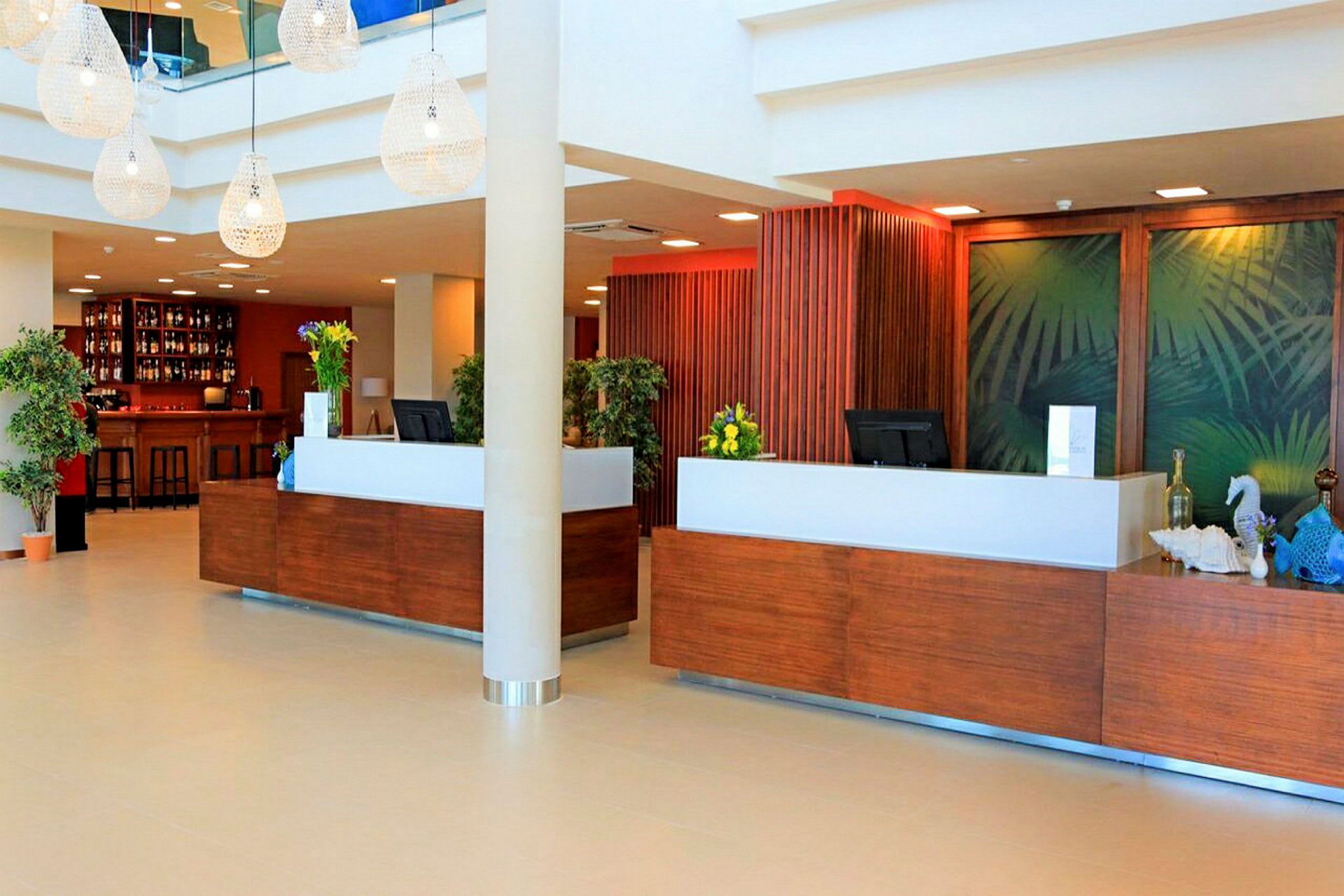 Hotellin aula, jossa vastaanottotiski ja taustakoriste. (Tekoälyn luoma teksti)