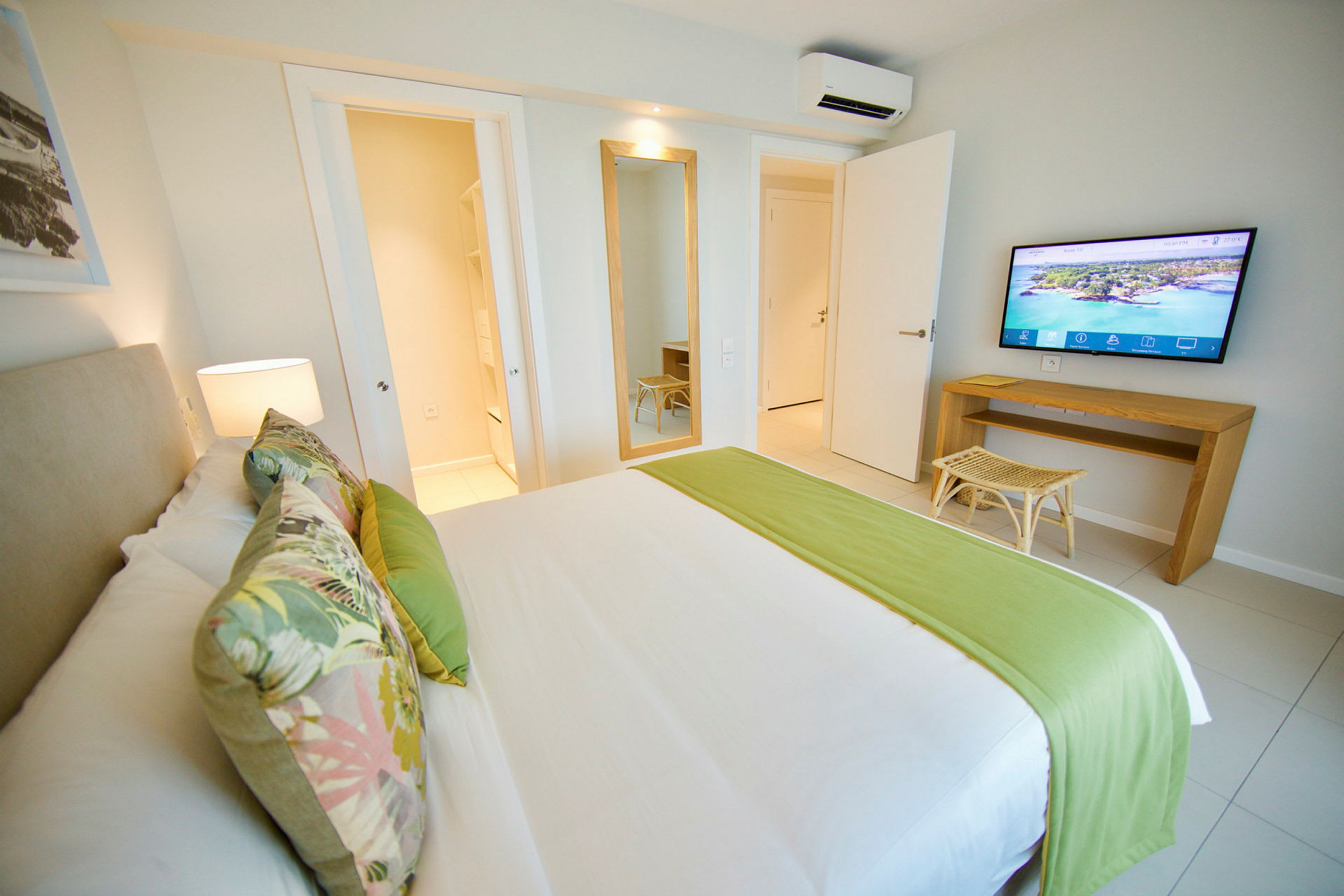 Hotellihuone, jossa sänky, seinäpeili ja televisio. (Tekoälyn luoma teksti)