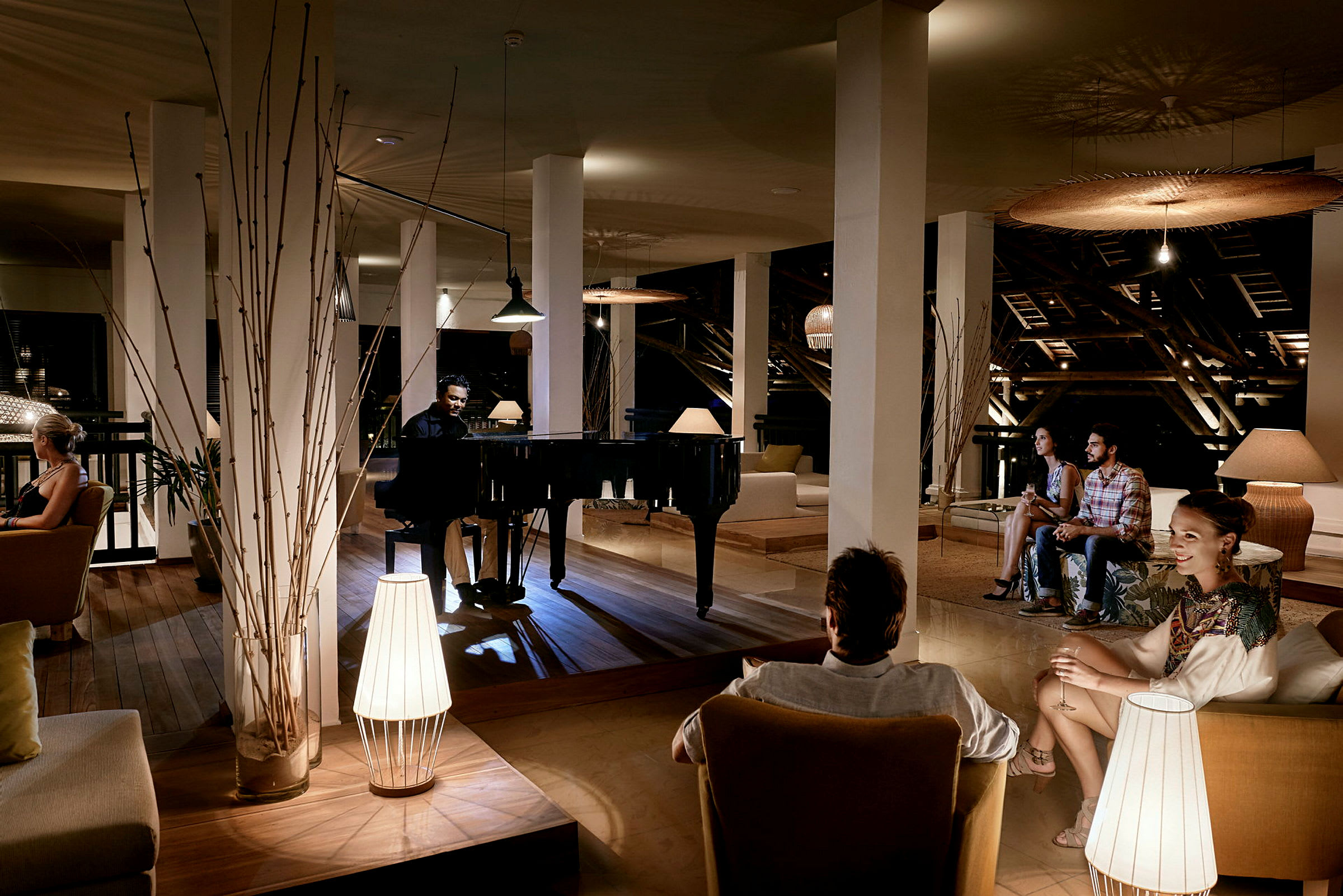 Tyylikäs lounge, jossa on flyygeli ja istumapaikkoja himmeässä valaistuksessa. (Tekoälyn luoma teksti)