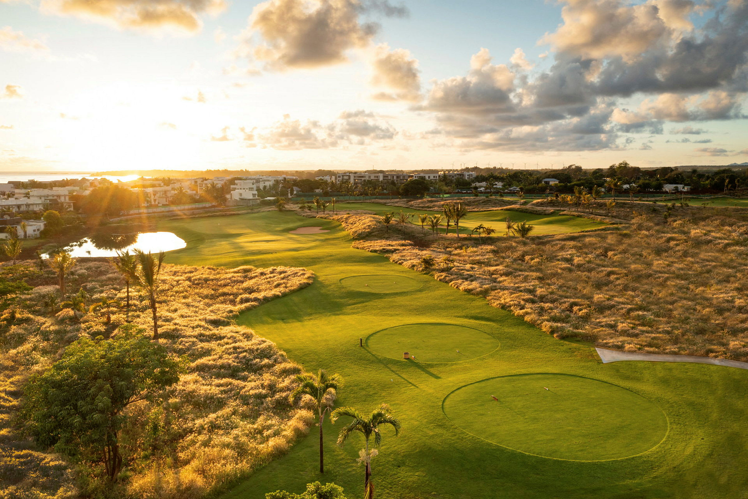 Näkymä golfkentälle auringonlaskussa ympäröivällä maisemalla. (Tekoälyn luoma teksti)