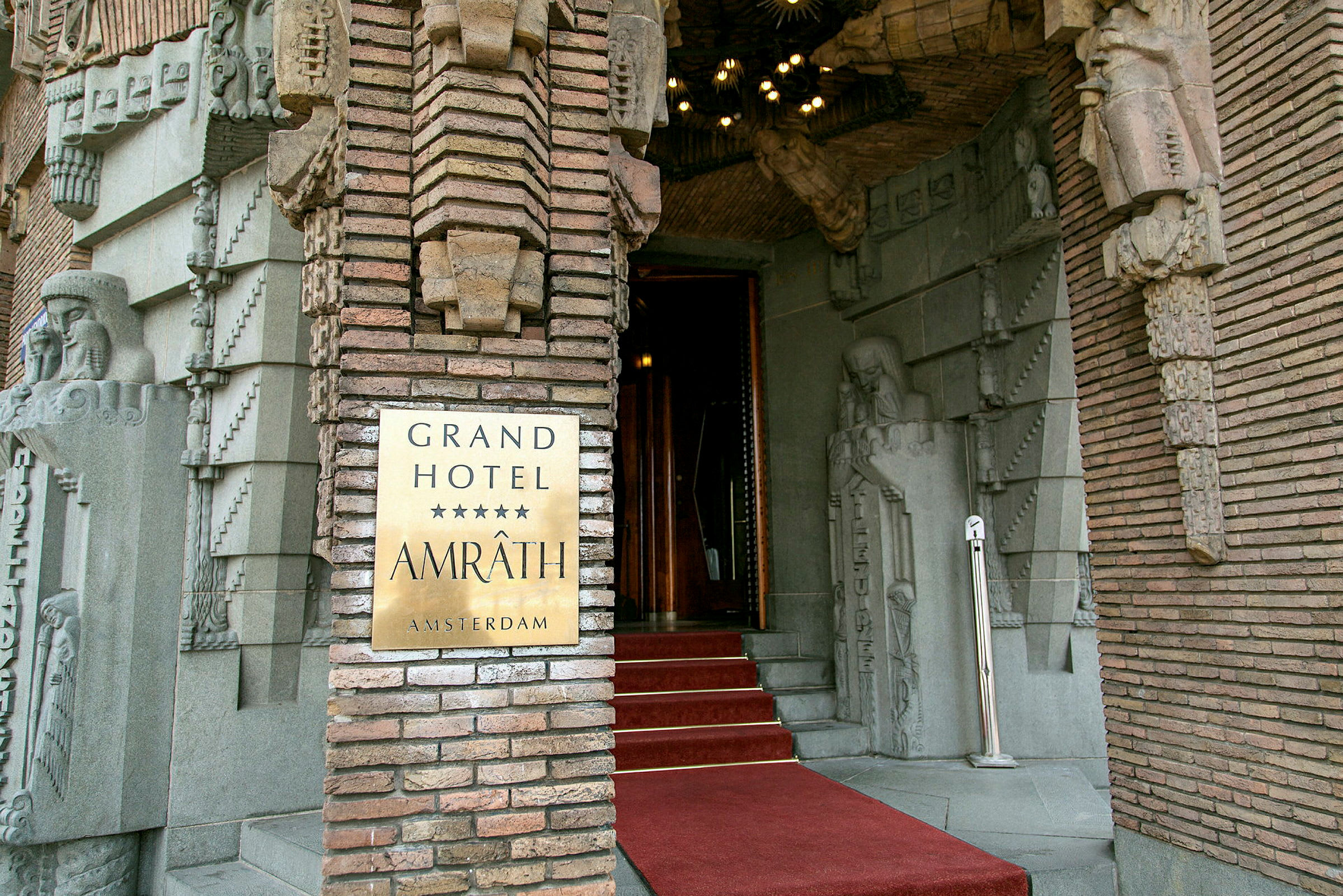 Grand Hotel Amrâth -hotellin sisäänkäynti koristeellisilla kivikoristeluilla. (Tekoälyn luoma teksti)