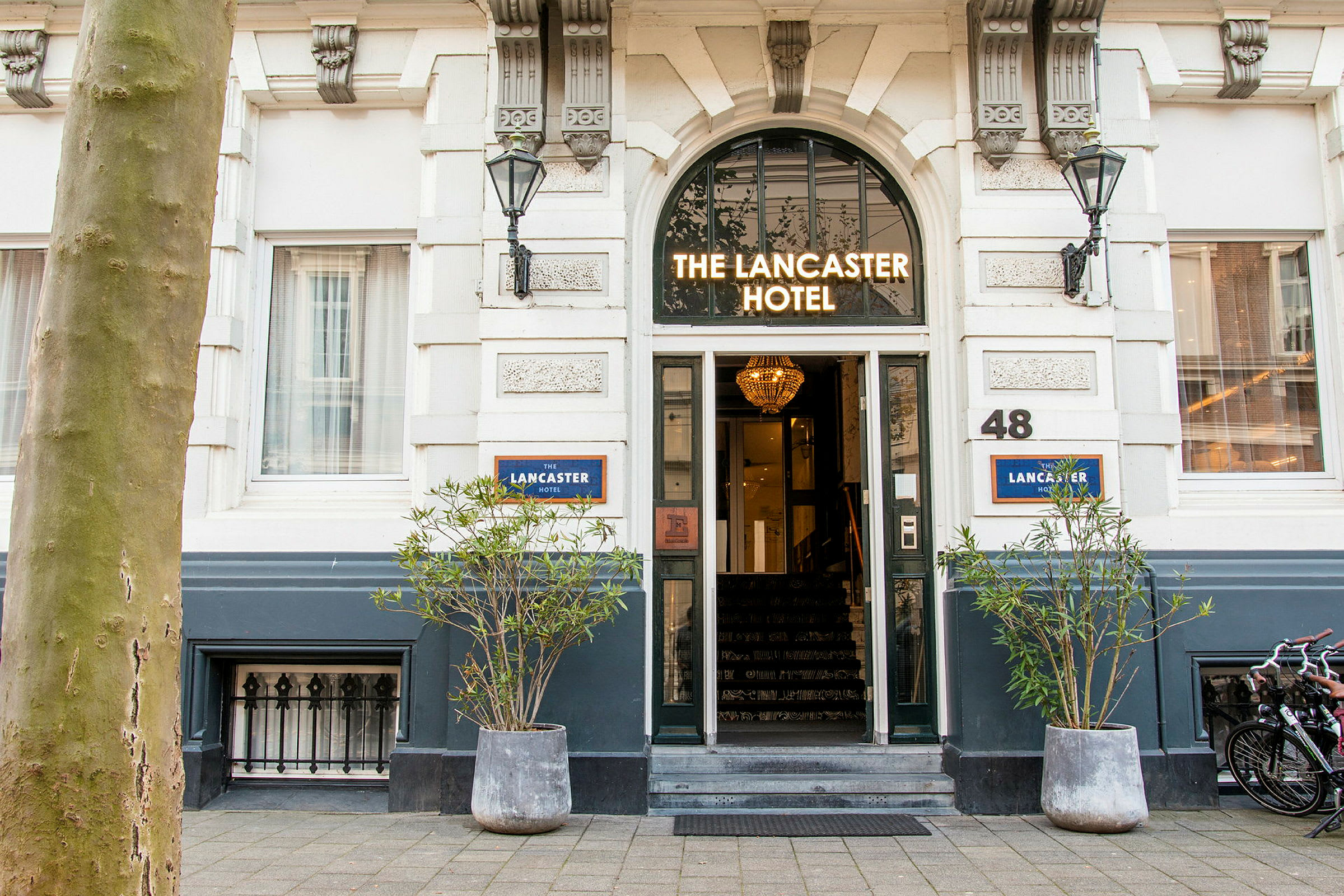 Hotellin sisäänkäynti, jonka yläpuolella on kyltti 'The Lancaster Hotel'. (Tekoälyn luoma teksti)