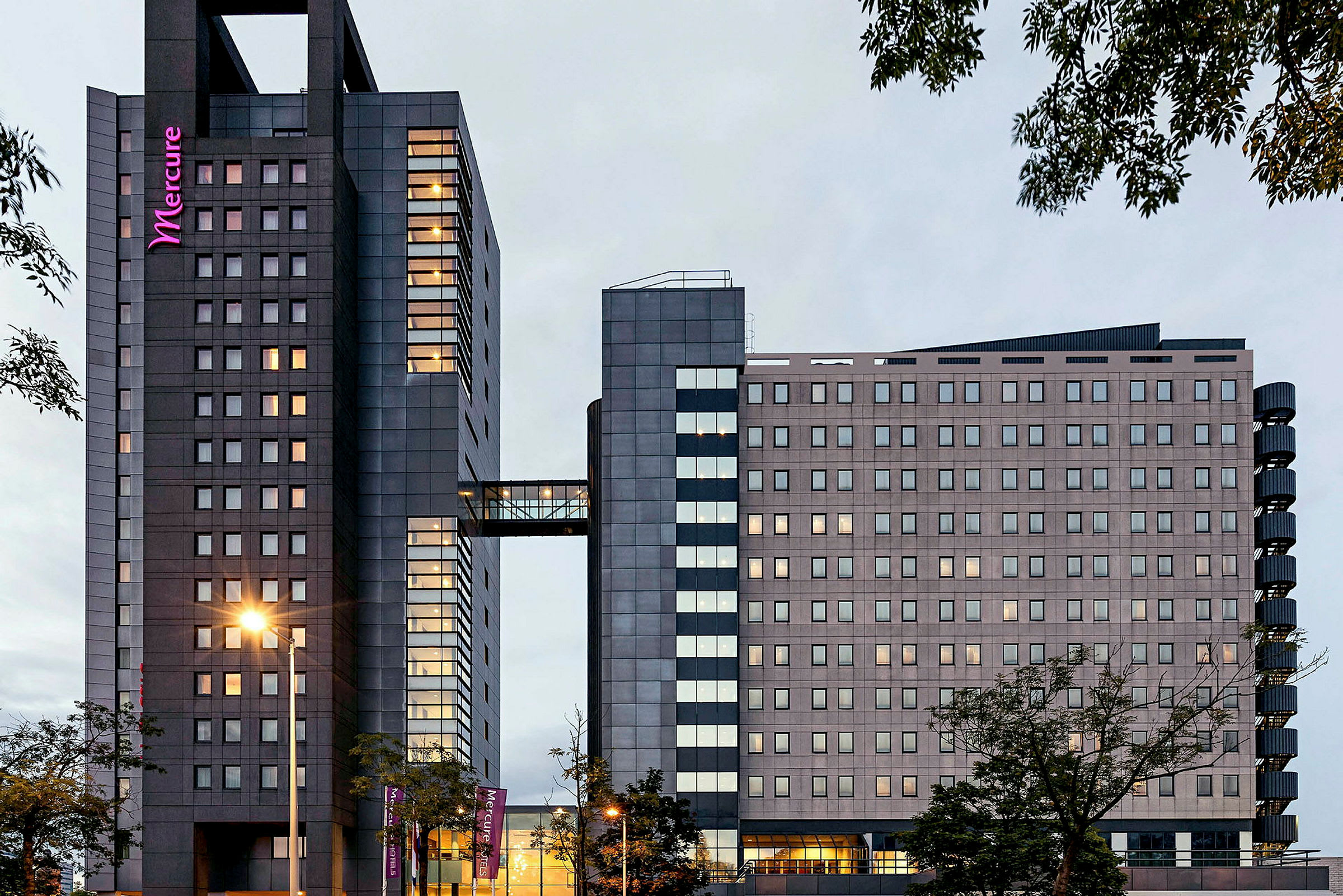 Moderni hotellirakennus lasijulkisivulla ja korkeatornirakenteella. (Tekoälyn luoma teksti)