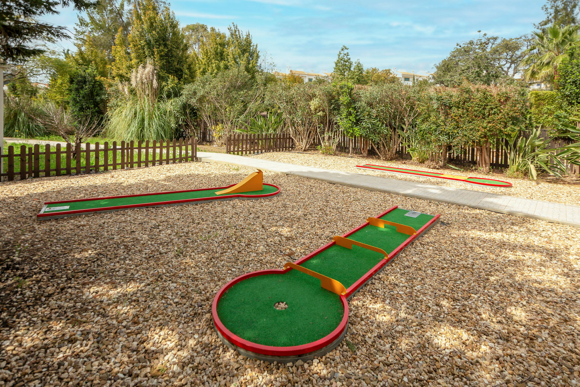 Minigolf-ratoja, ympärillä aitoja ja vehreyttä. (Tekoälyn luoma teksti)