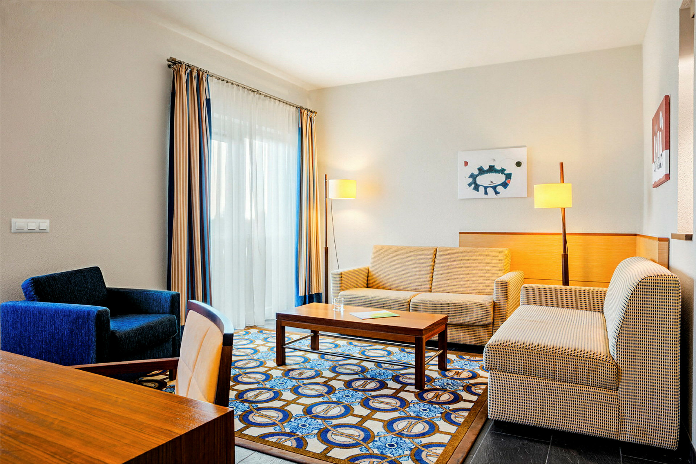 Hotellihuone, jossa sohva, nojatuoli ja pöytä. (Tekoälyn luoma teksti)