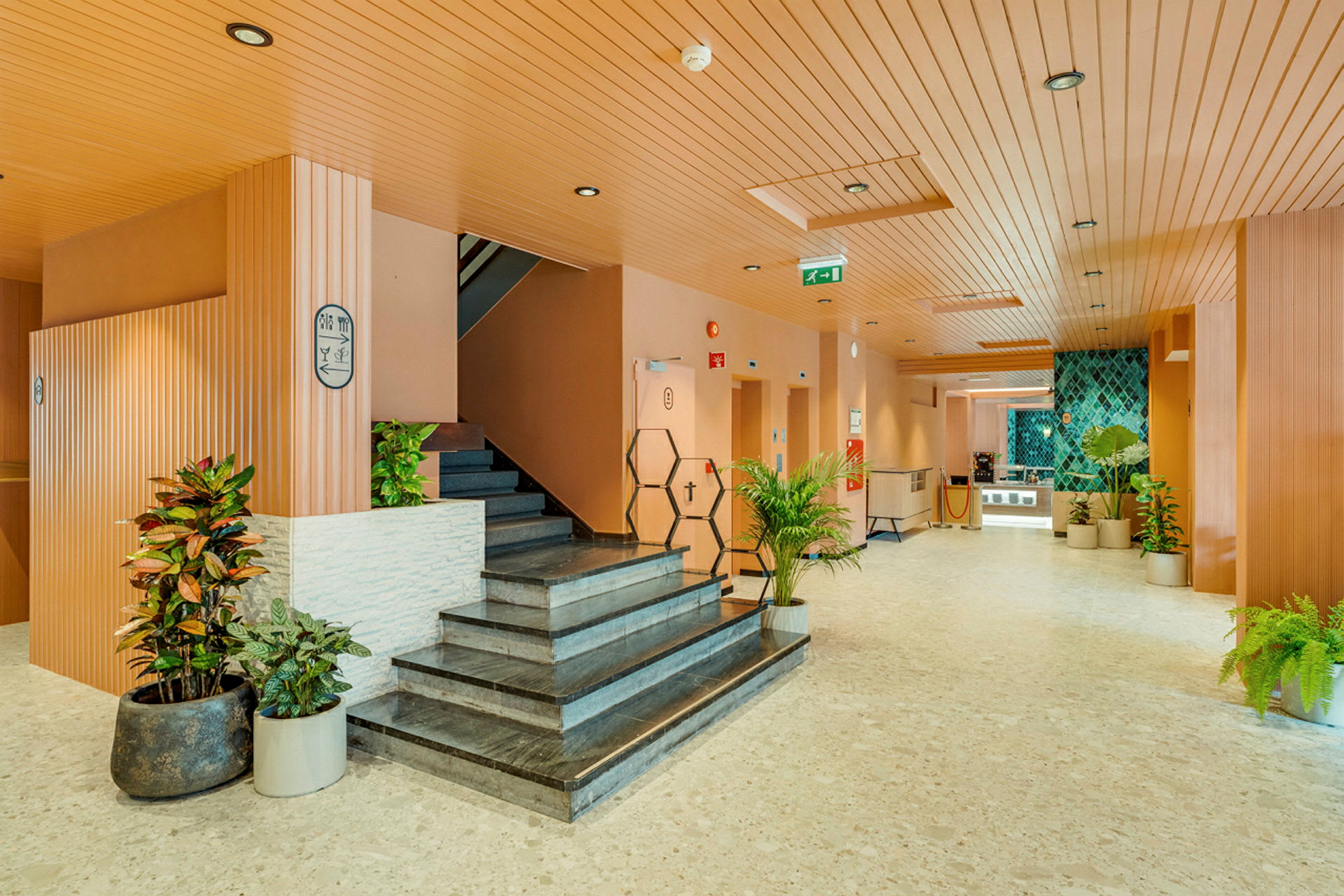 Hotellin aula, jossa portaat ja koristekasveja. (Tekoälyn luoma teksti)