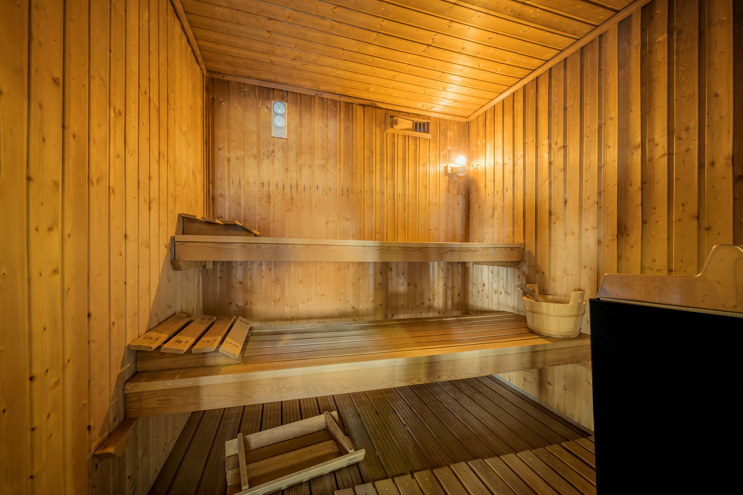 Perinteinen sauna, jossa puupaneelit, puupenkit ja kiuas. (Tekoälyn luoma teksti)