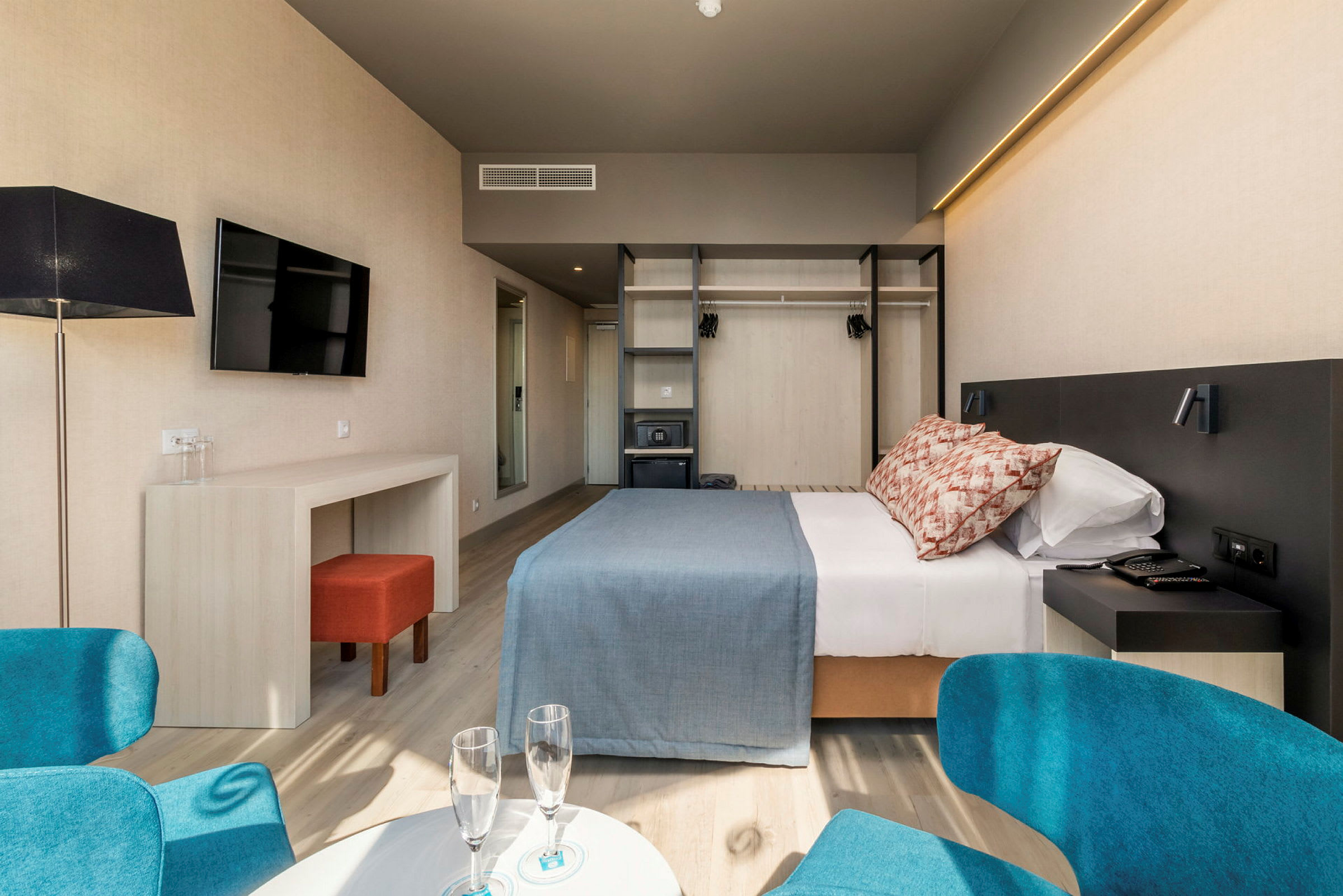 Hotellihuone, jossa on parisänky, työpöytä, tuoli ja vaatekaappi. (Tekoälyn luoma teksti)