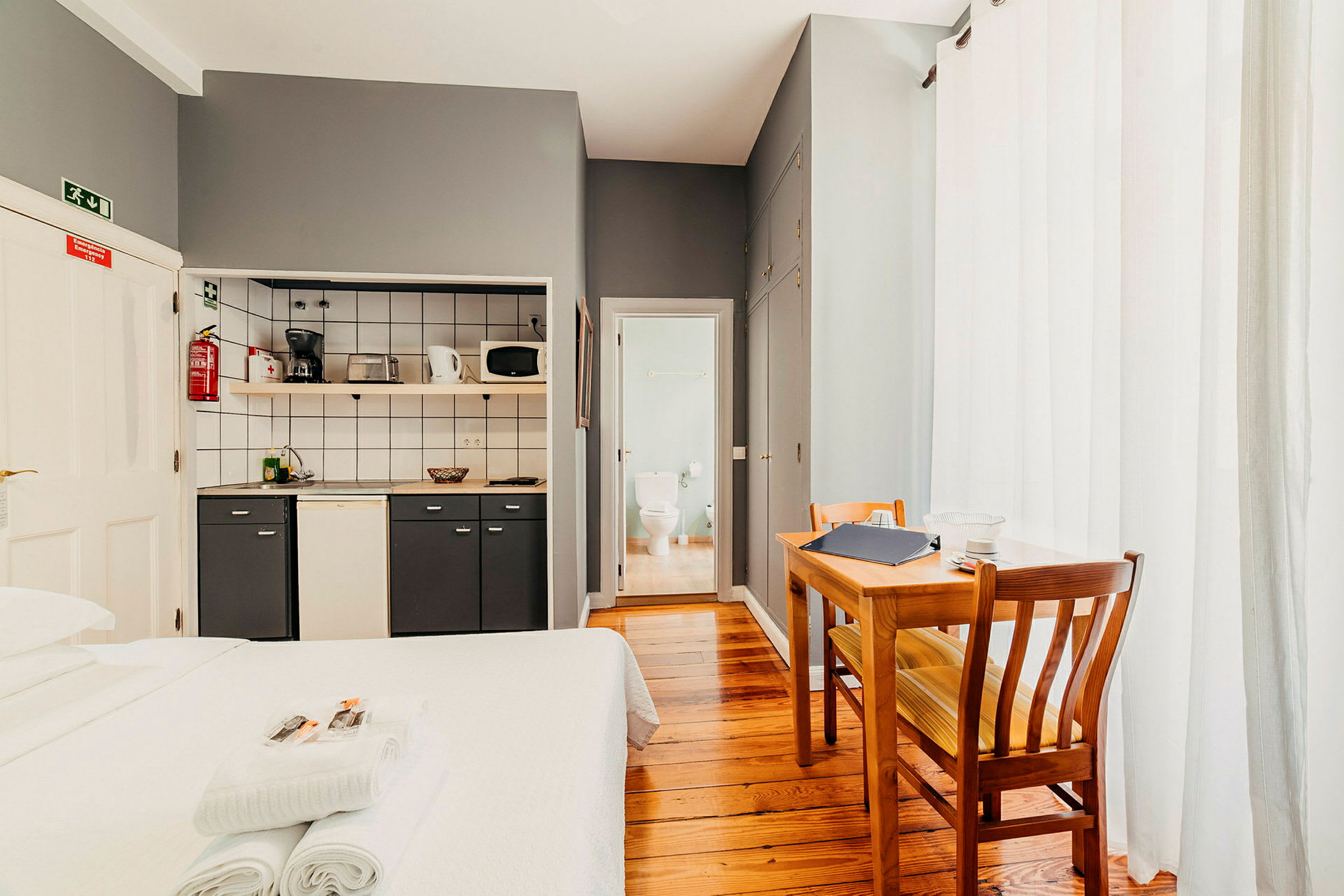 Hotellihuone, jossa keittiöosa, ruokapöytä ja kylpyhuone. (Tekoälyn luoma teksti)