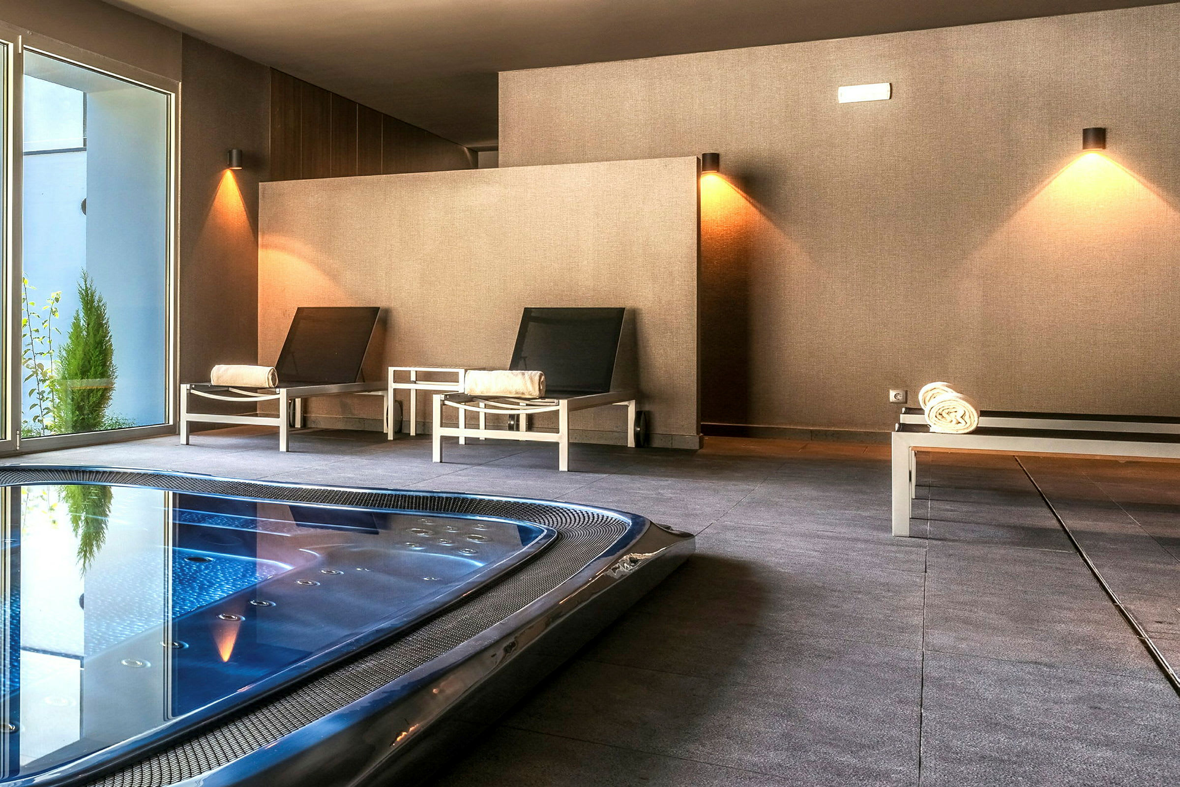 Kuva spa-alueesta istuipaikkoineen ja altaineen. (Tekoälyn luoma teksti)