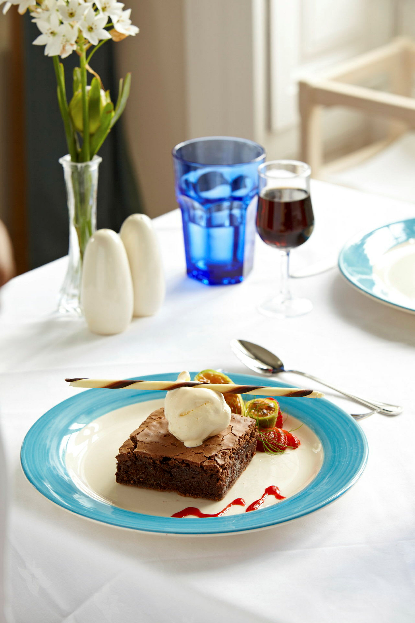 Lautasella brownie ja jäätelö, koristeltu hedelmillä ja kastikkeella. (Tekoälyn luoma teksti)