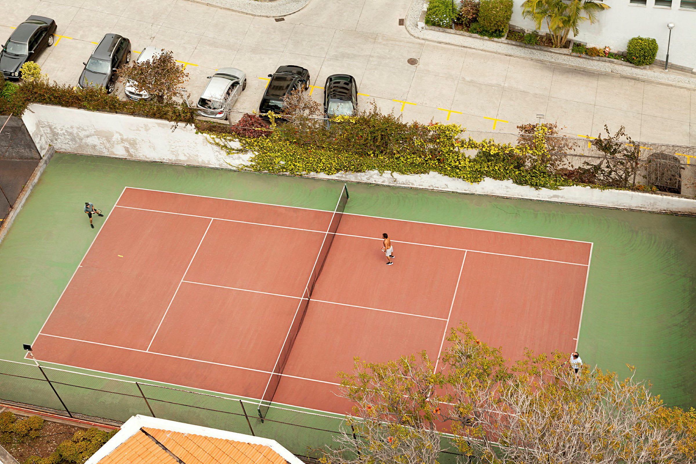 Tenniskenttä ylhäältä katsottuna, kaksi pelaajaa pelaamassa. (Tekoälyn luoma teksti)