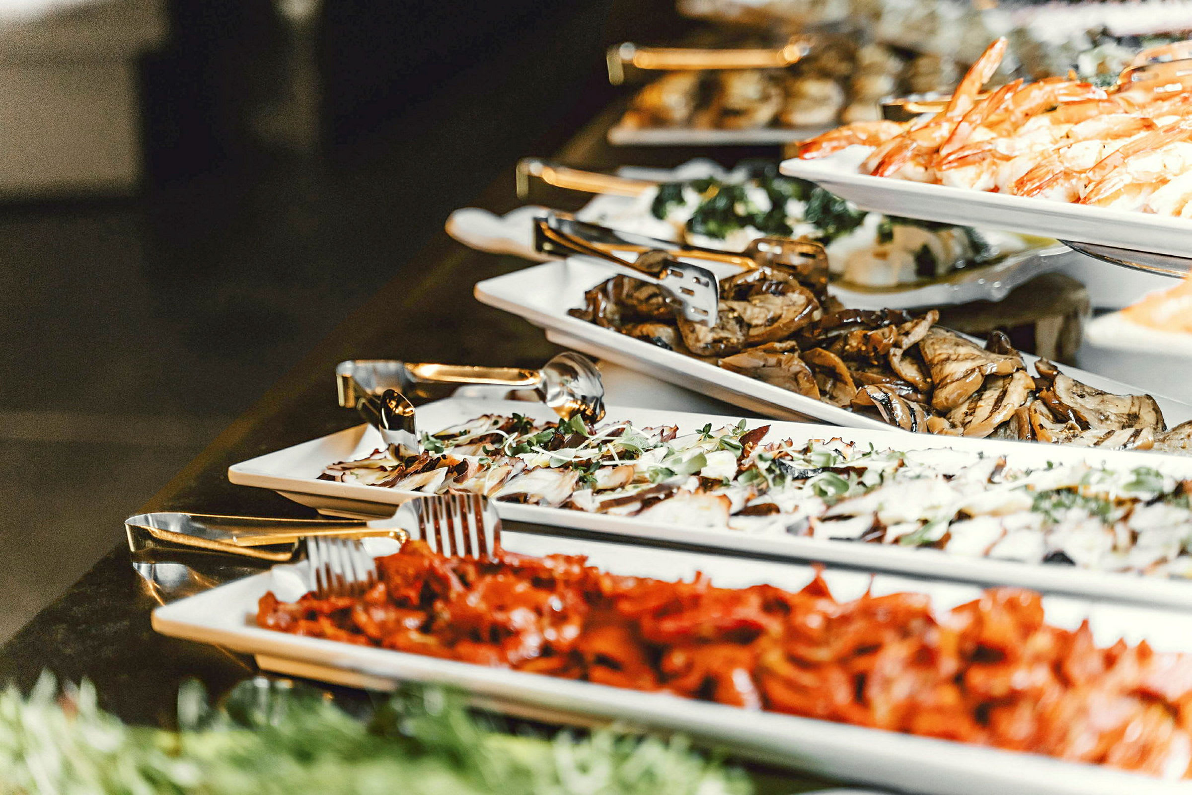 Buffet, jossa erilaisia ruokia, mukaan lukien äyriäiset ja vihannekset. (Tekoälyn luoma teksti)