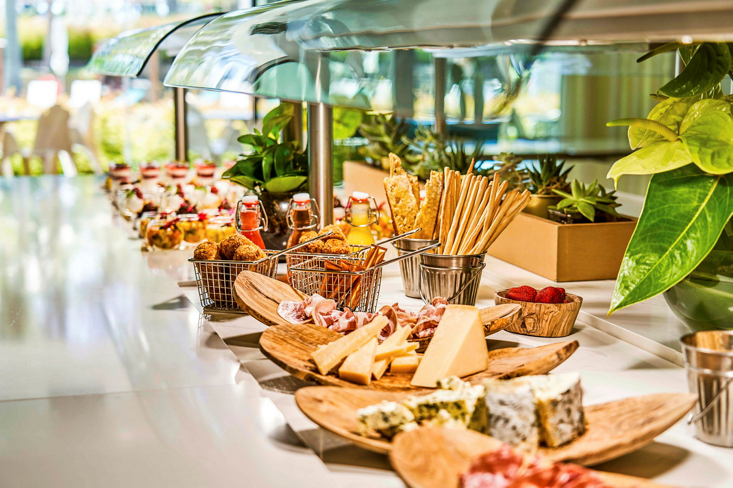 Buffet, jossa erilaisia ruokia, mukaan lukien juustoja, leikkeleitä ja jälkiruokia. (Tekoälyn luoma teksti)