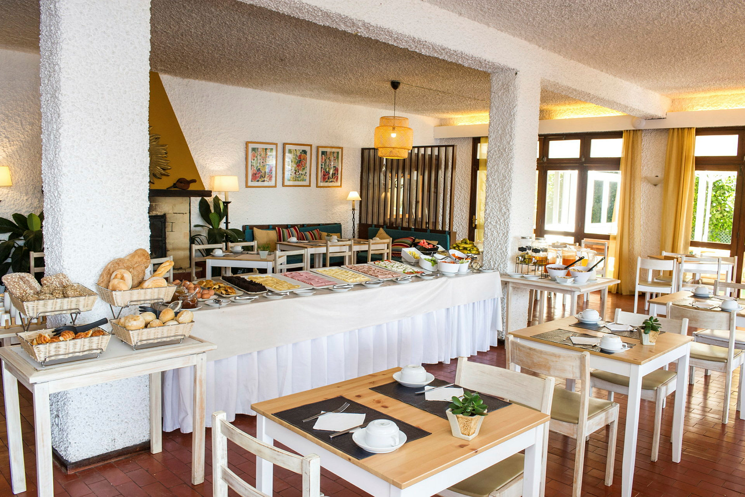 Hotellin ravintola-alue, jossa on aamiaisbuffet ja istuimia. (Tekoälyn luoma teksti)