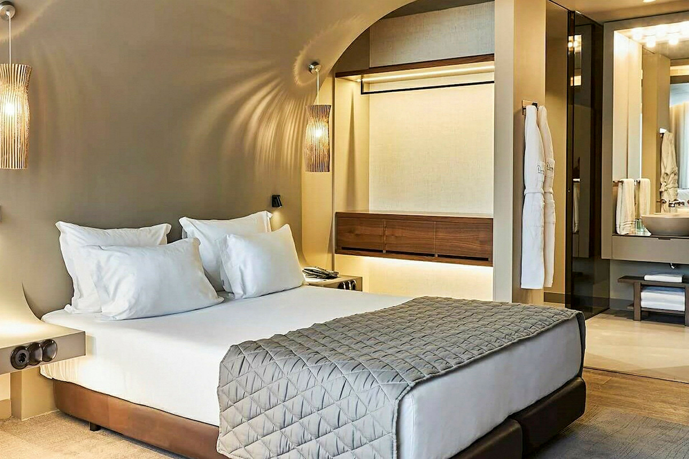 Moderni hotellihuone, jossa on parisänky ja oleskelualue. (Tekoälyn luoma teksti)