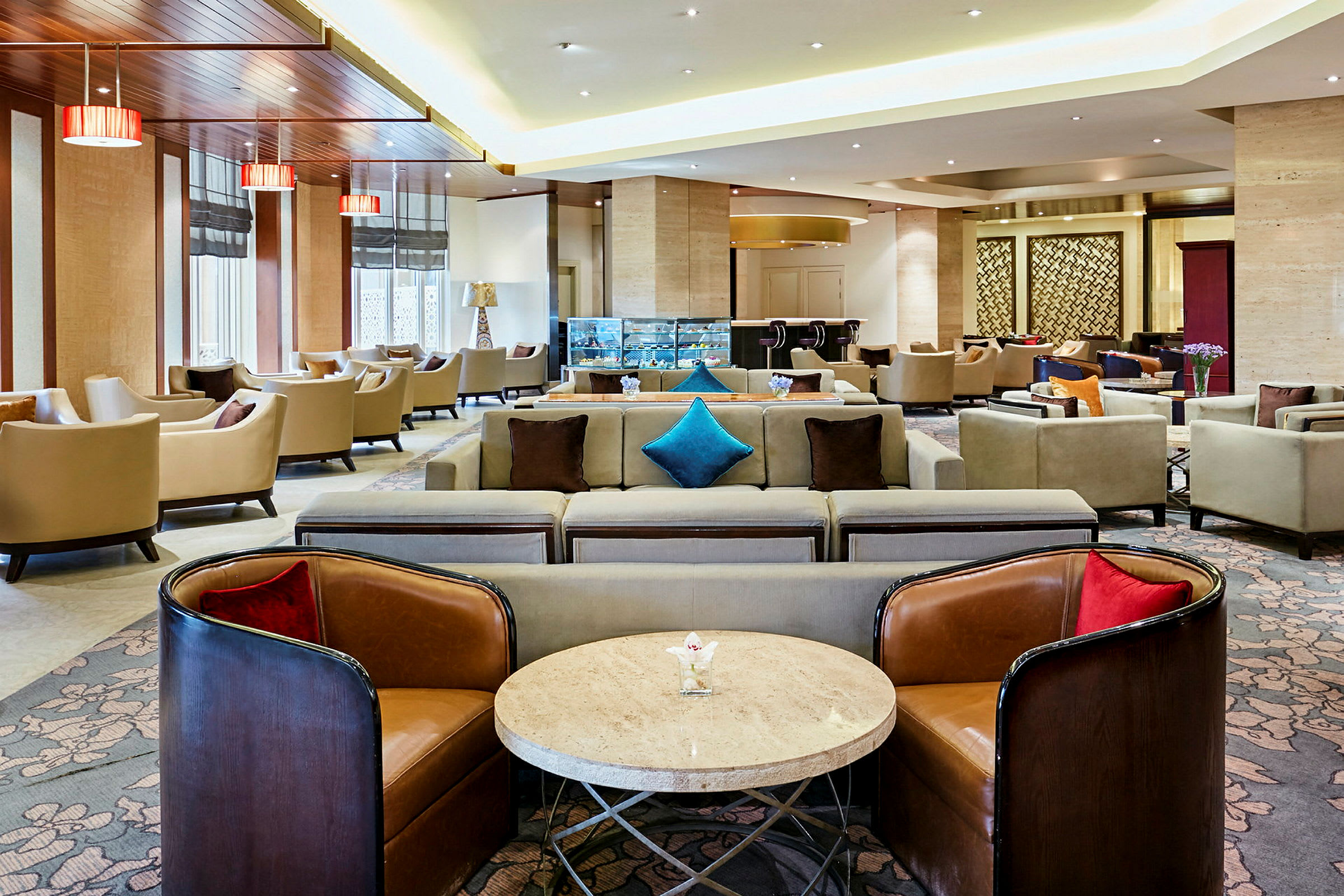 Kuva modernista lounge-alueesta, jossa on sohvia ja nojatuoleja sekä sohvapöytiä. (Tekoälyn luoma teksti)