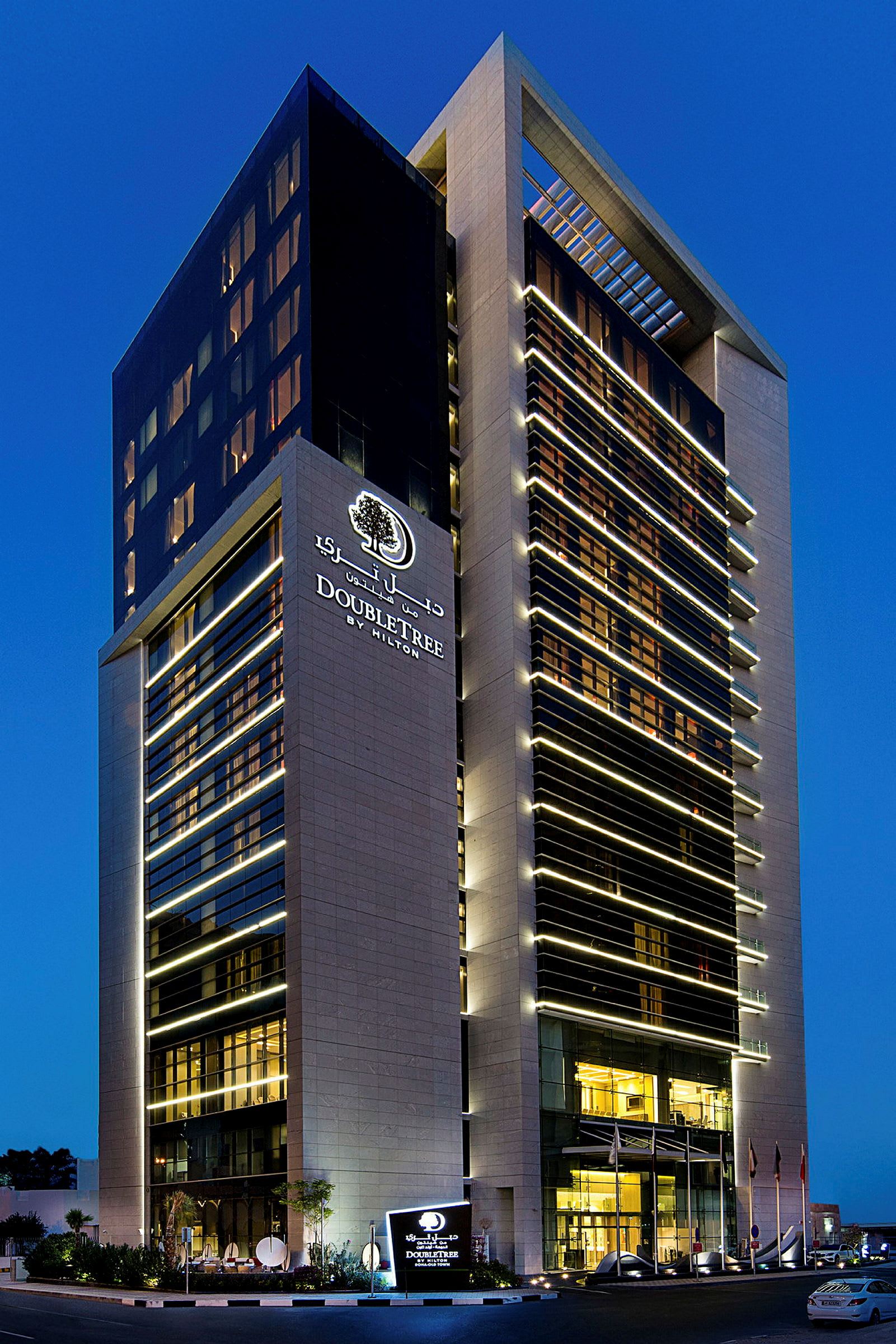 Kuva hotellista nimeltä DoubleTree by Hilton, jota ympäröi sininen taivas. (Tekoälyn luoma teksti)