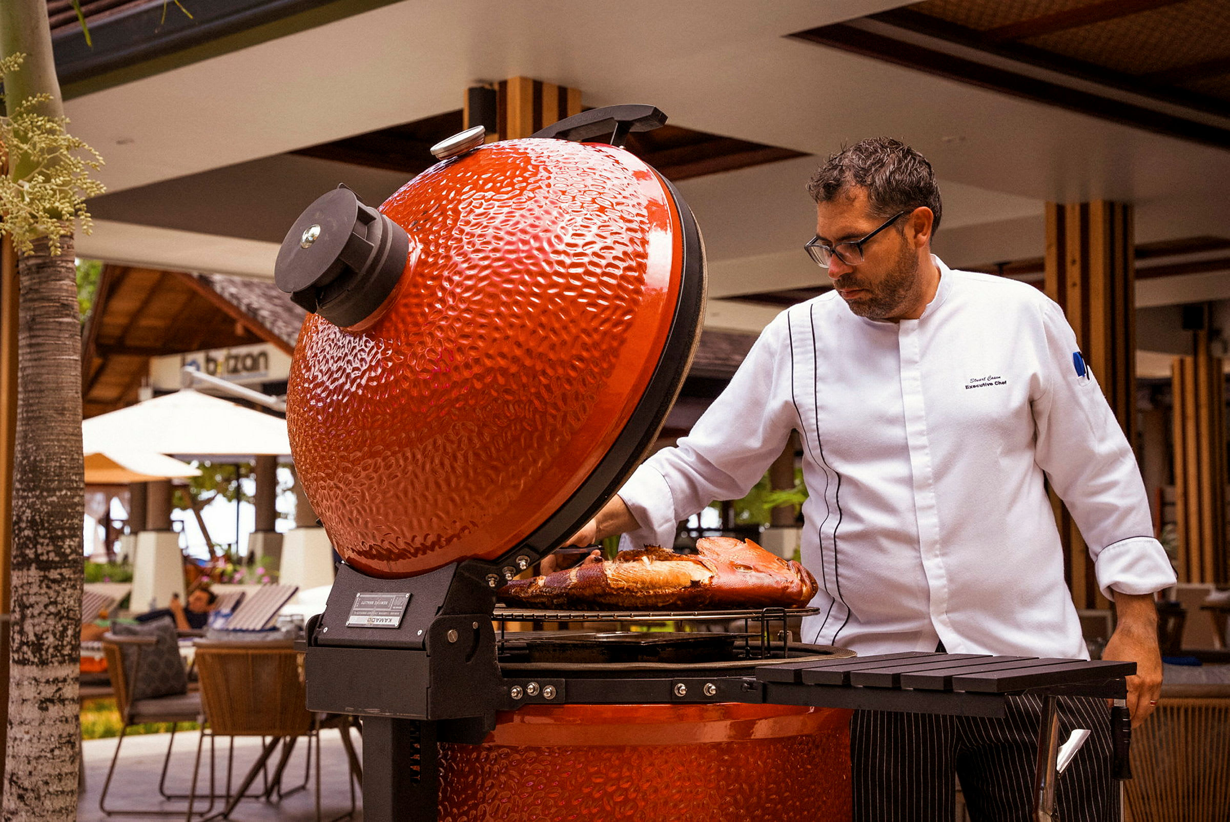 Henkilö avatun punaisen grillin äärellä, jossa ruokaa ritilällä. (Tekoälyn luoma teksti)
