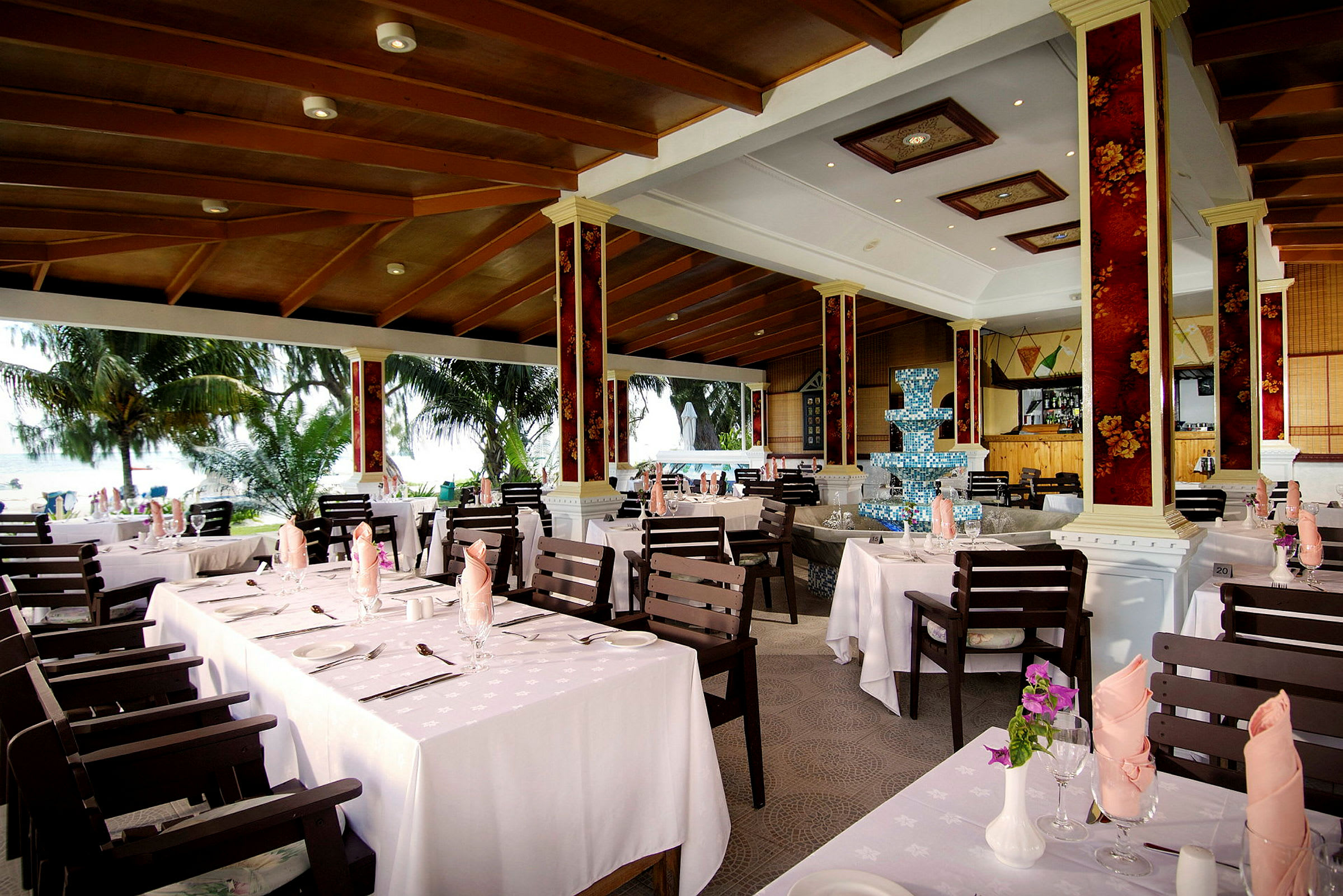 Kuva ravintolasta, jossa katetut pöydät ja näkymä vehreään ulkotilaan. (Tekoälyn luoma teksti)