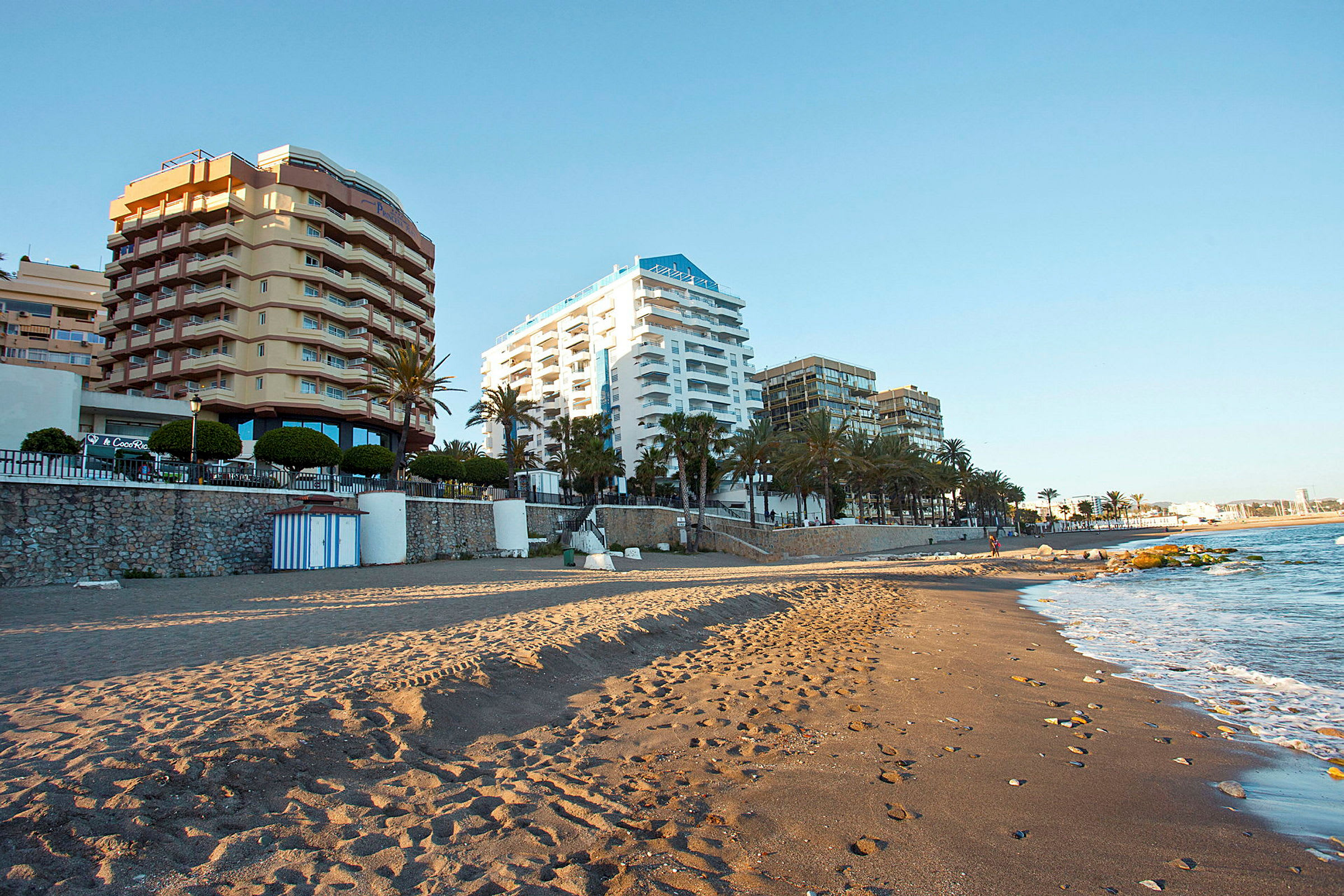 Ranta, taustalla muutamia rakennuksia. (Tekoälyn luoma teksti)