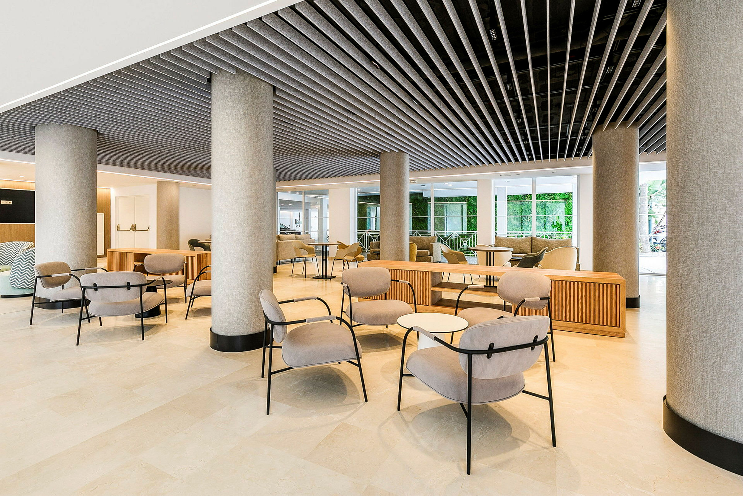 Hotellin aula modernilla kalusteilla ja pylväillä. (Tekoälyn luoma teksti)