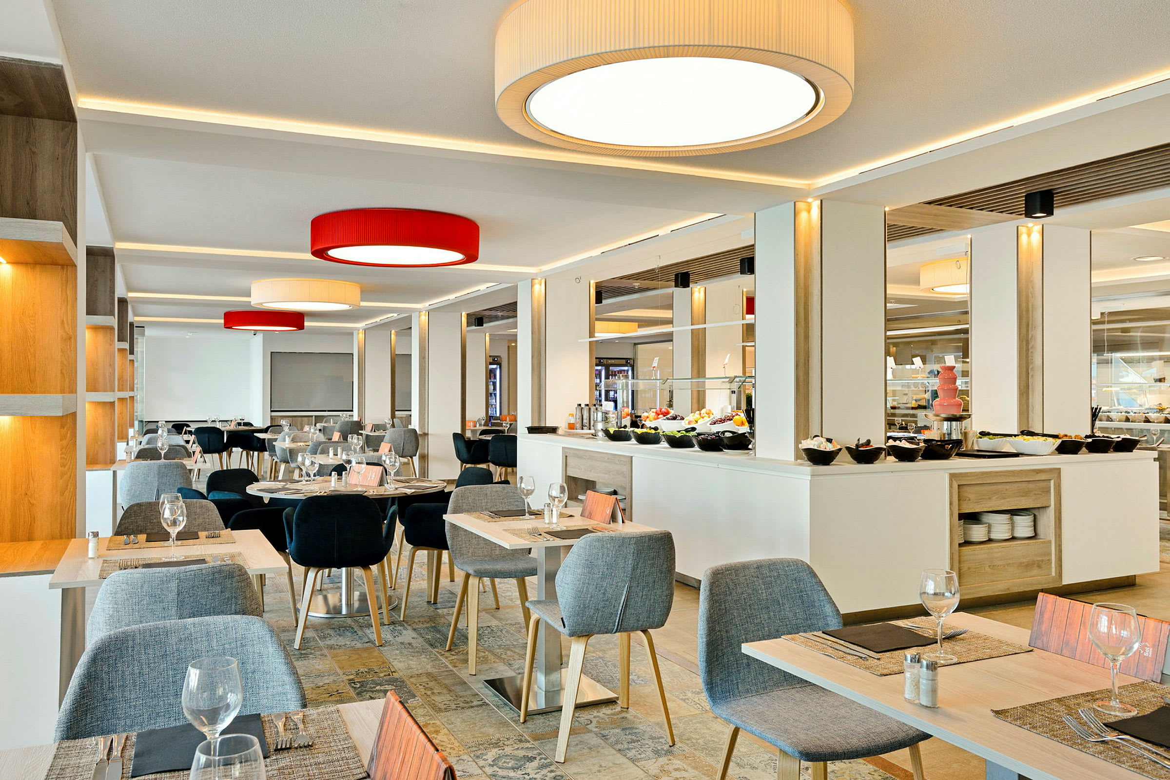 Valoisa ruokasalin sisustus, jossa on pöytiä ja tuoleja sekä buffet taustalla. (Tekoälyn luoma teksti)